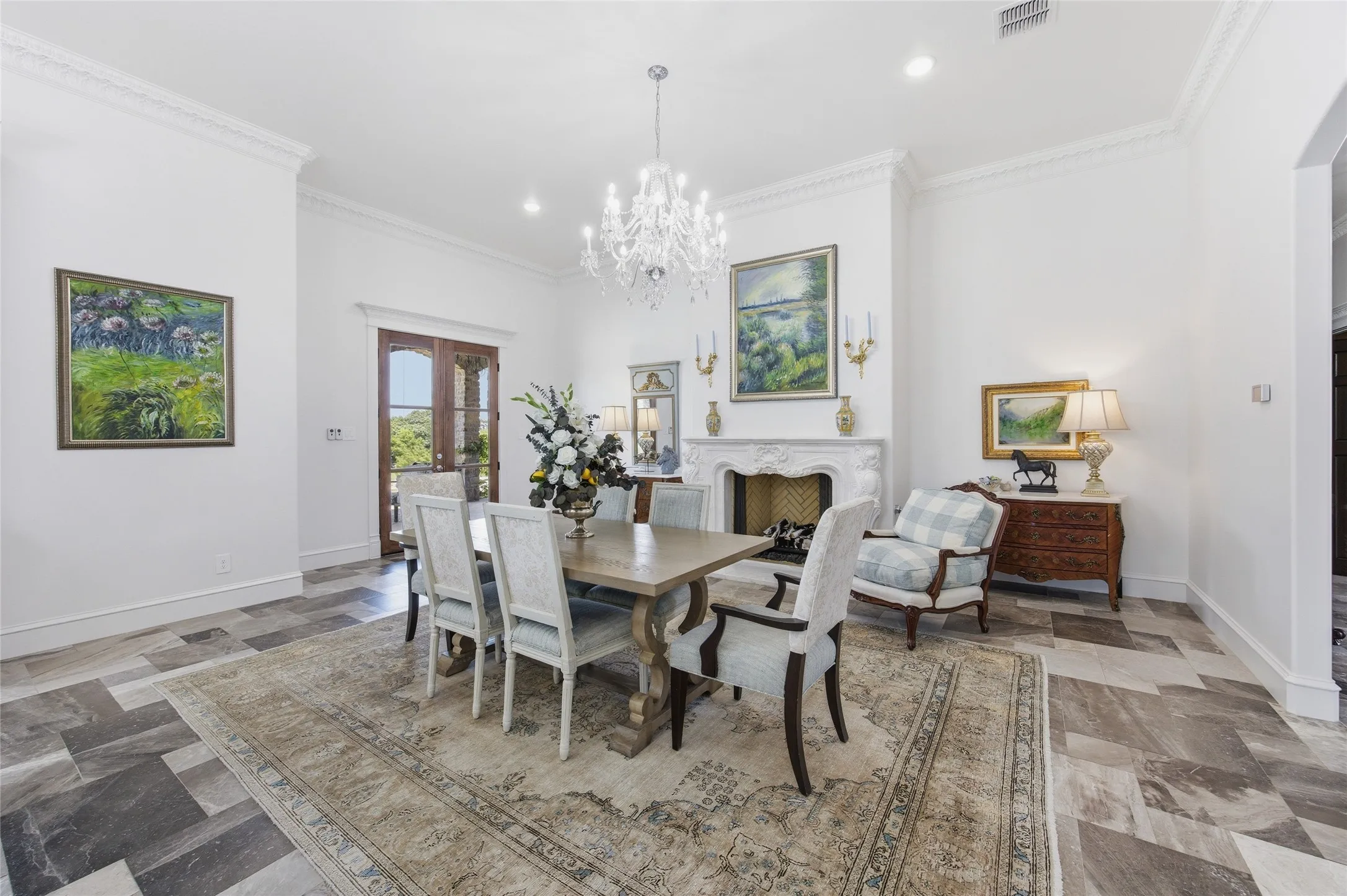 Spacious interior with crown molding, a decorative chandelier, and a carved stone fireplace