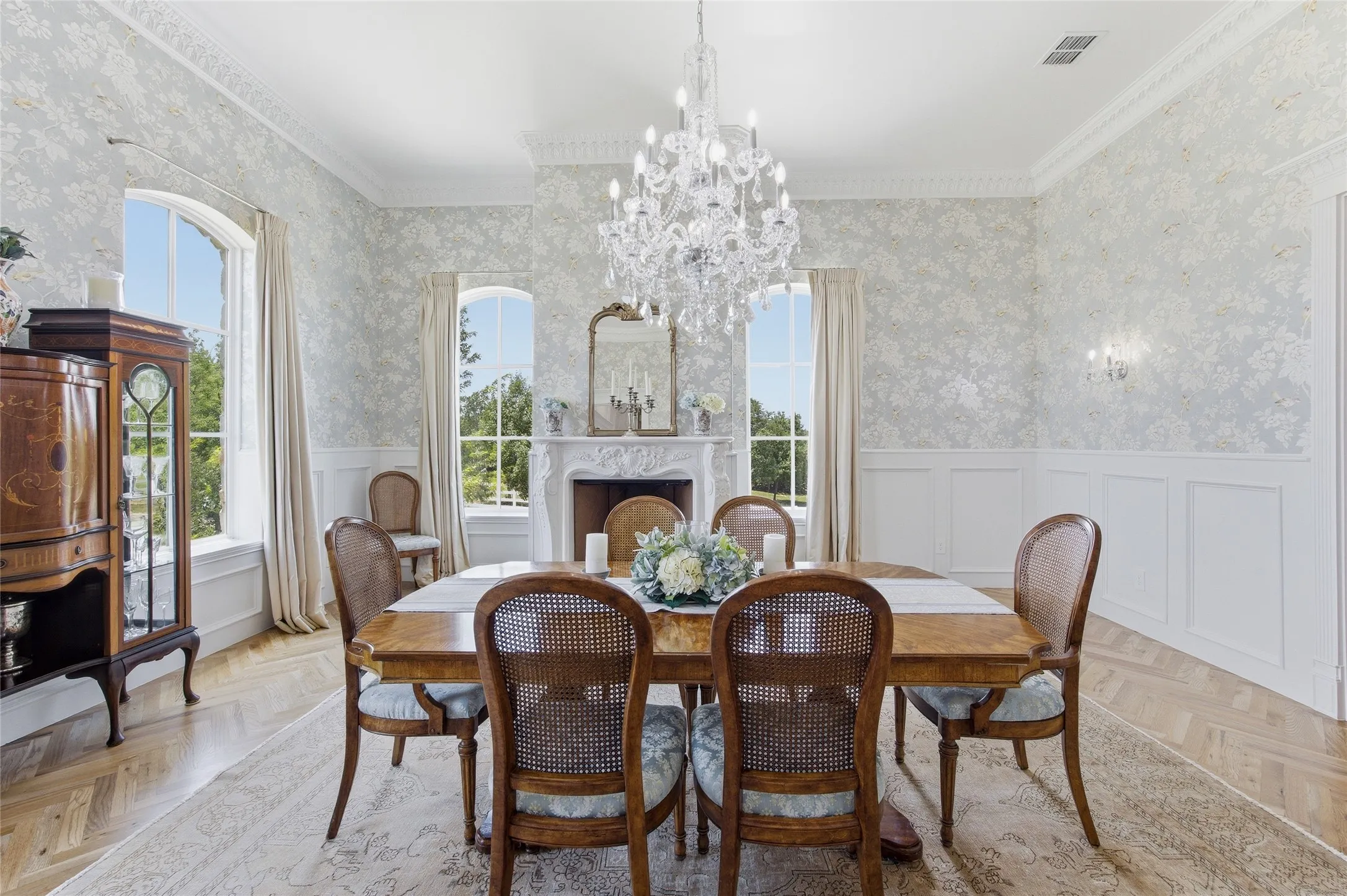 White paneled wainscoting and patterned wall covering define this space
