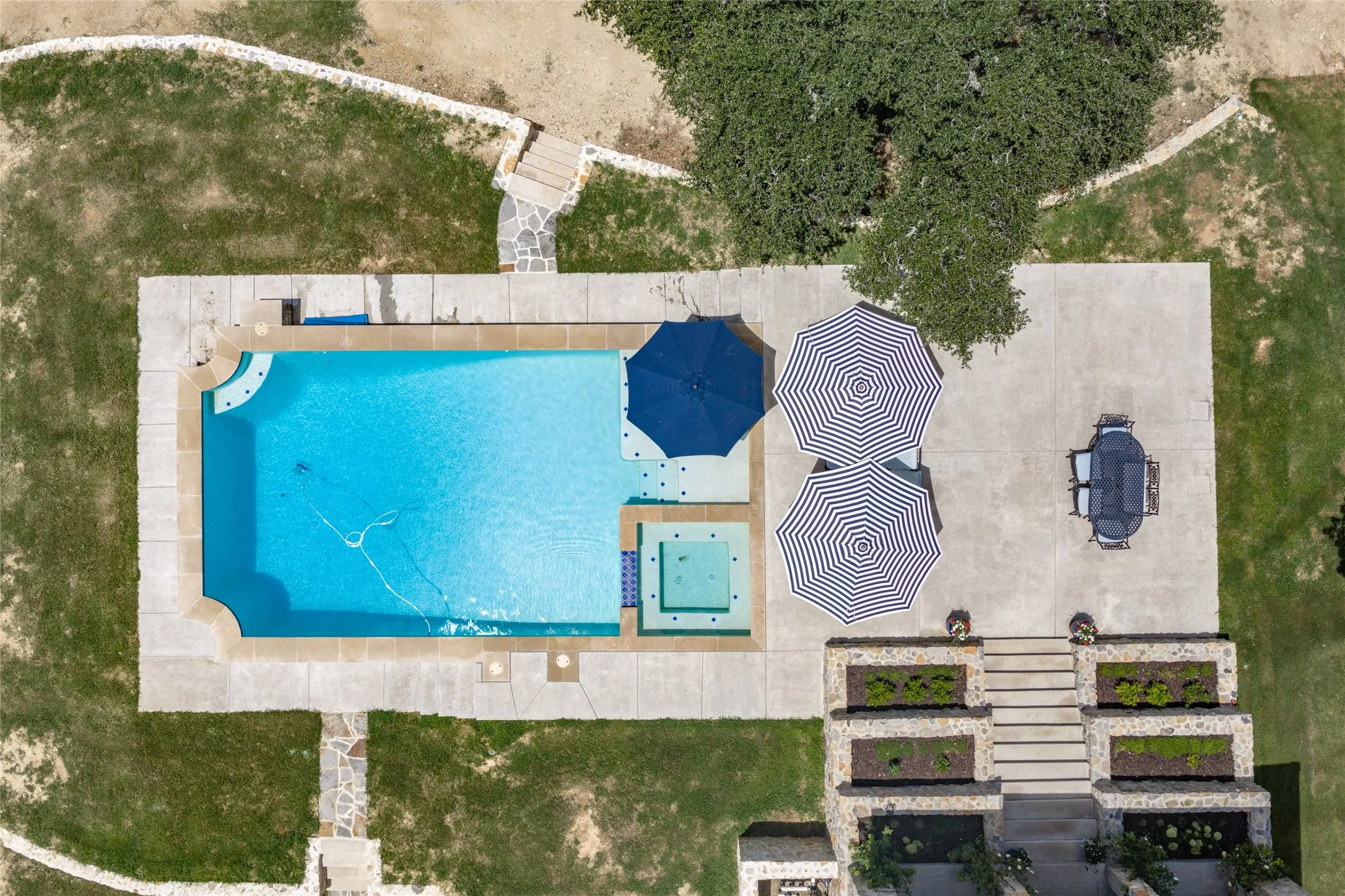 Rectangular swimming pool with integrated spa and broad concrete decking