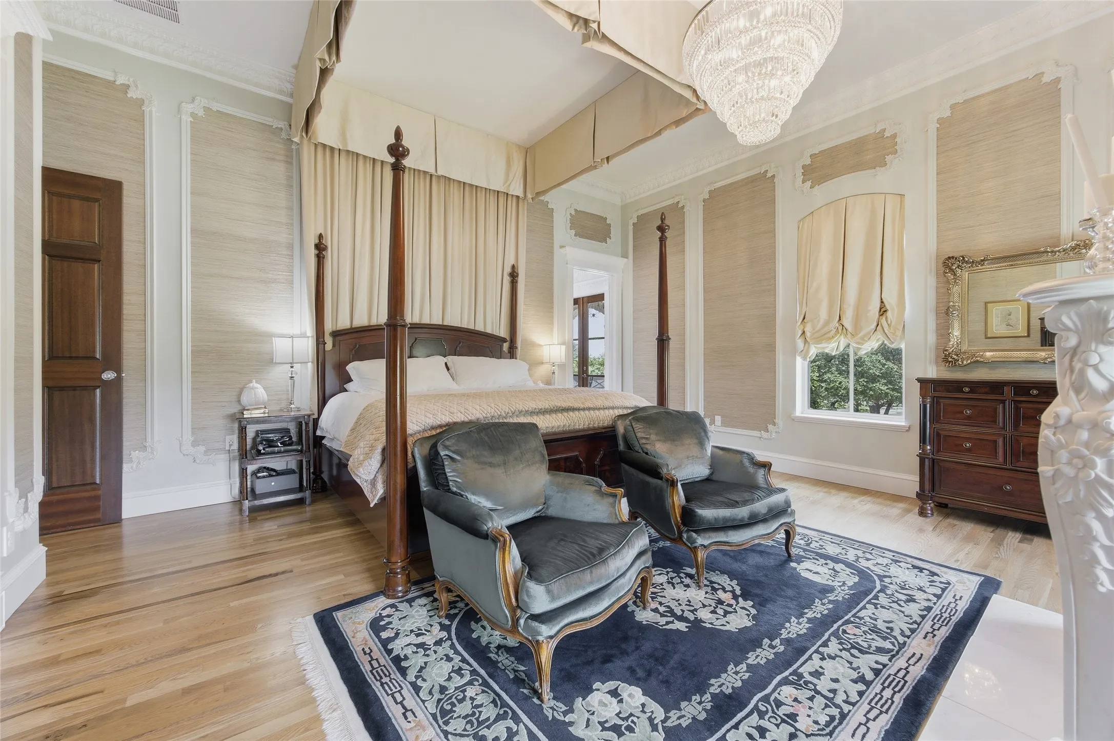 Hardwood flooring, ornate ceiling molding, decorative wall paneling, a large window, and a built-in fireplace