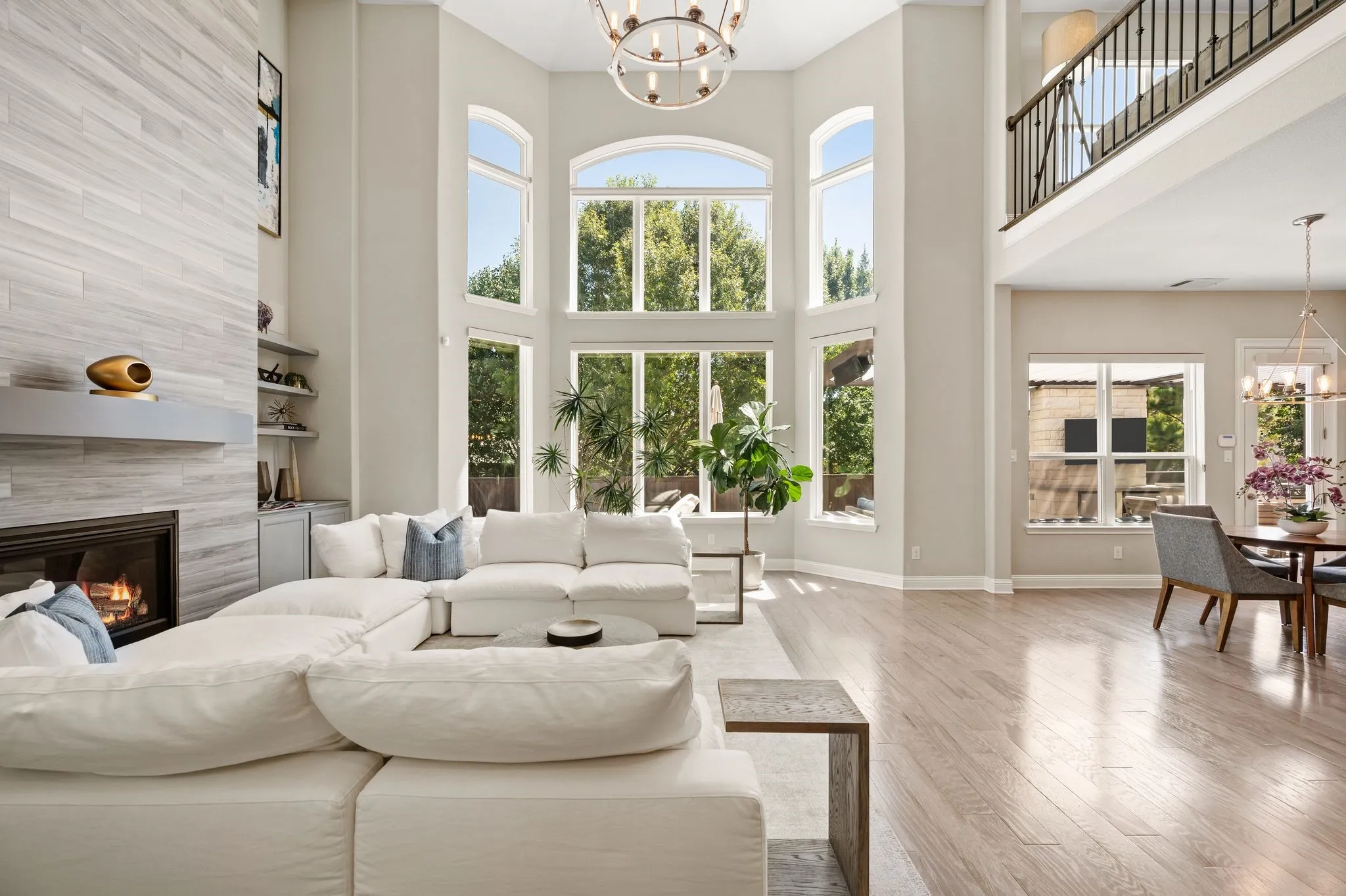 Soaring two-story great room with floor-to-ceiling arched windows flooding the space with natural light