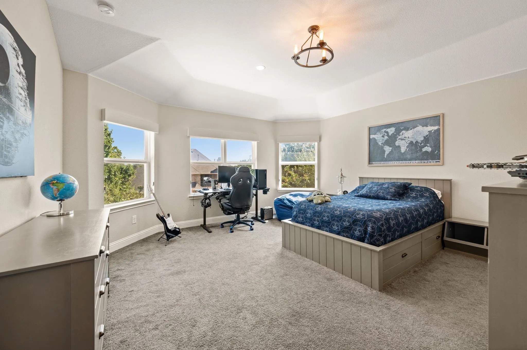 Recessed lighting, tray ceiling, multiple windows, built-in storage bed, and wall-mounted lighting fixture