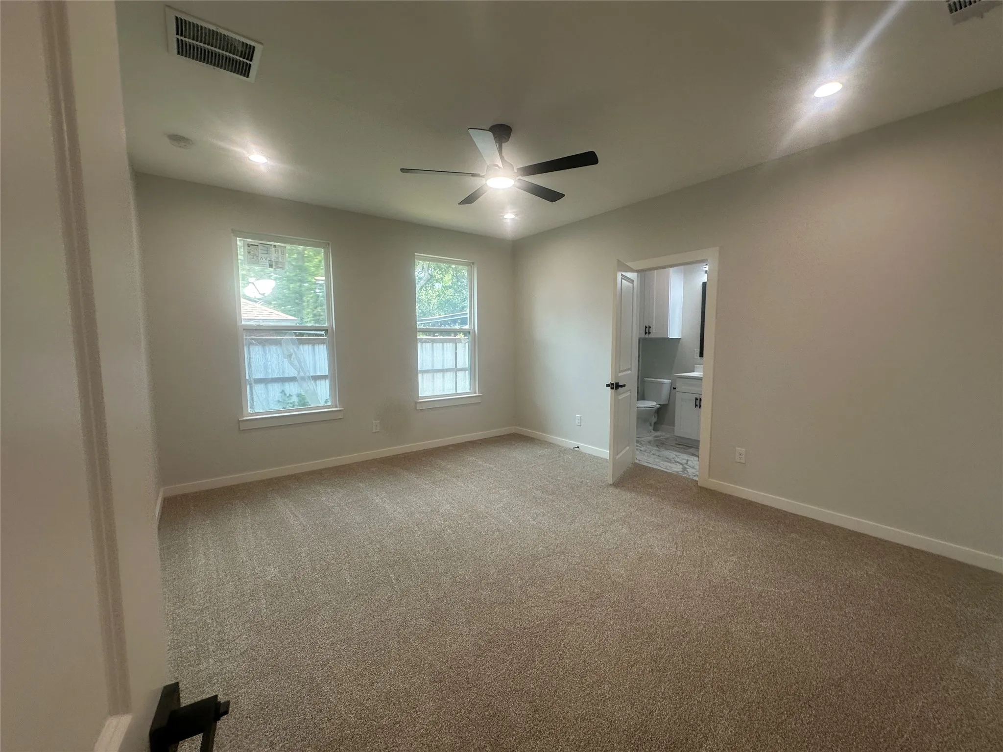 master bed with recessed lighting and fan