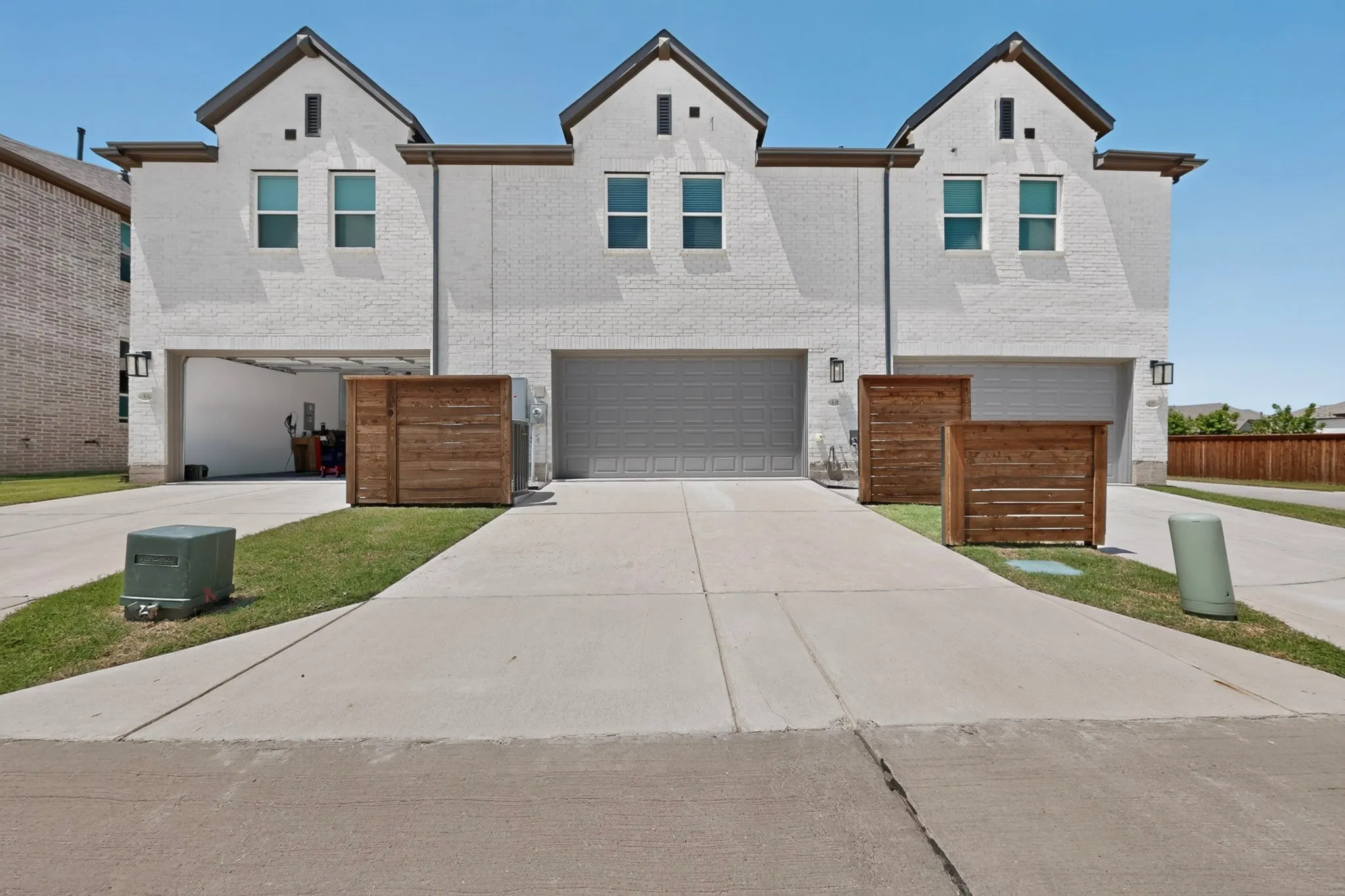 White brick exterior with dark trim and multiple gabled roofs