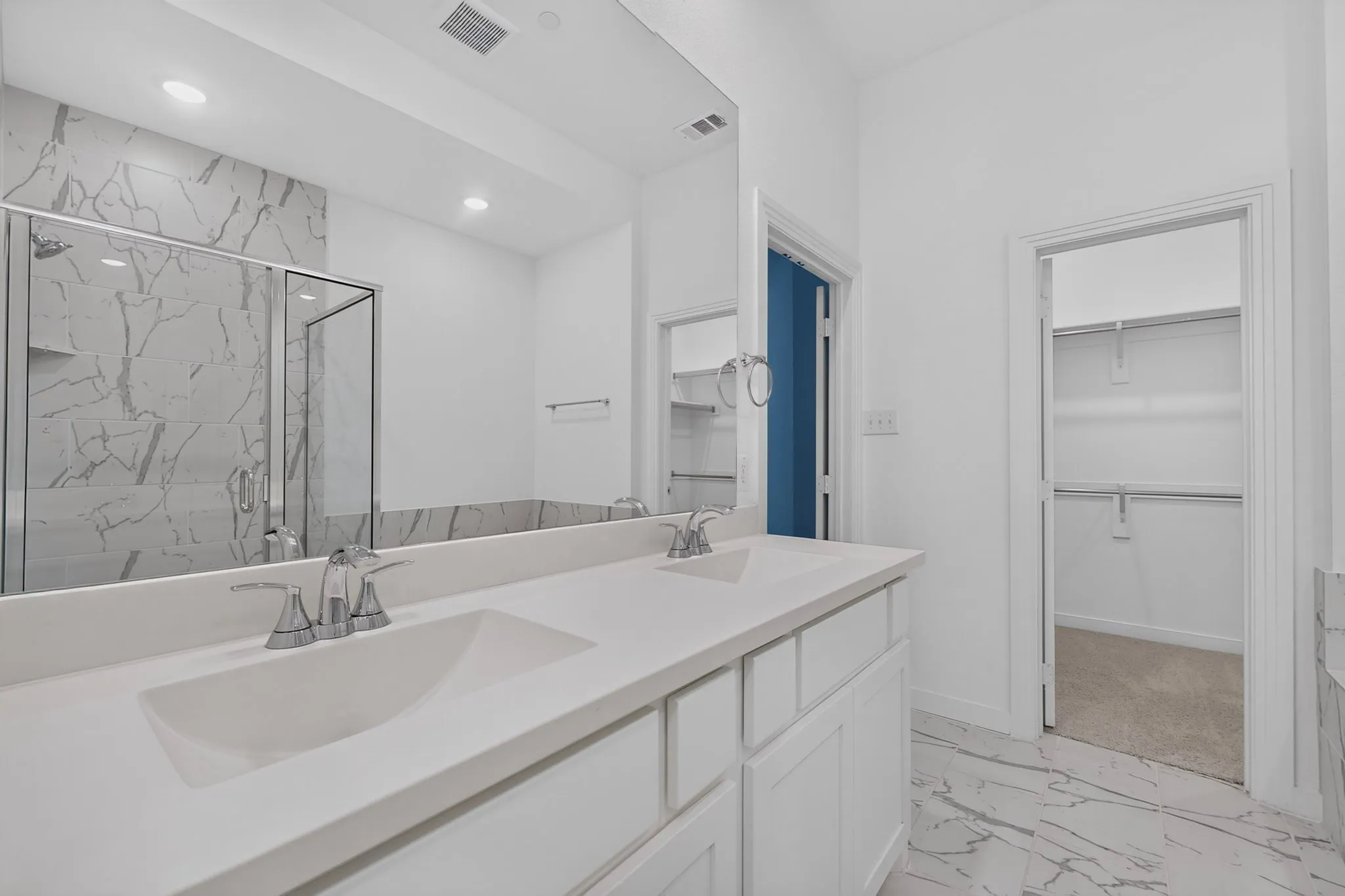 Dual vanity with undermount sinks, stone countertop, and chrome fixtures
