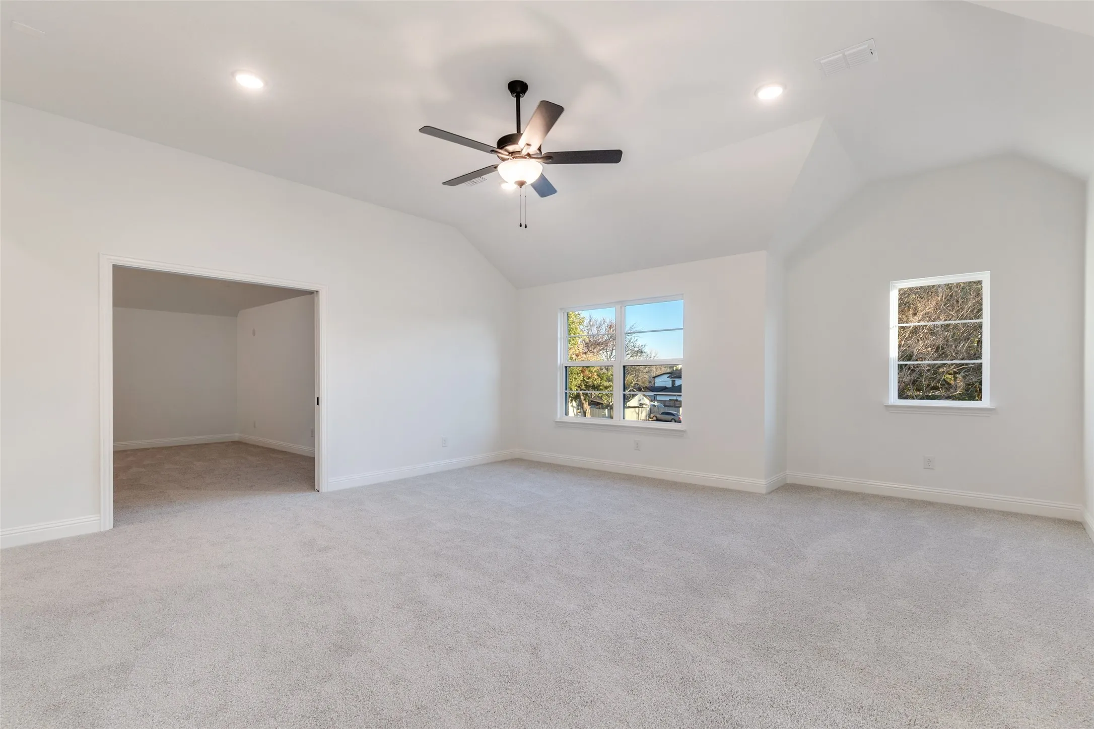 Bonus room with a vaulted ceiling, light colored carpet, and recessed lighting