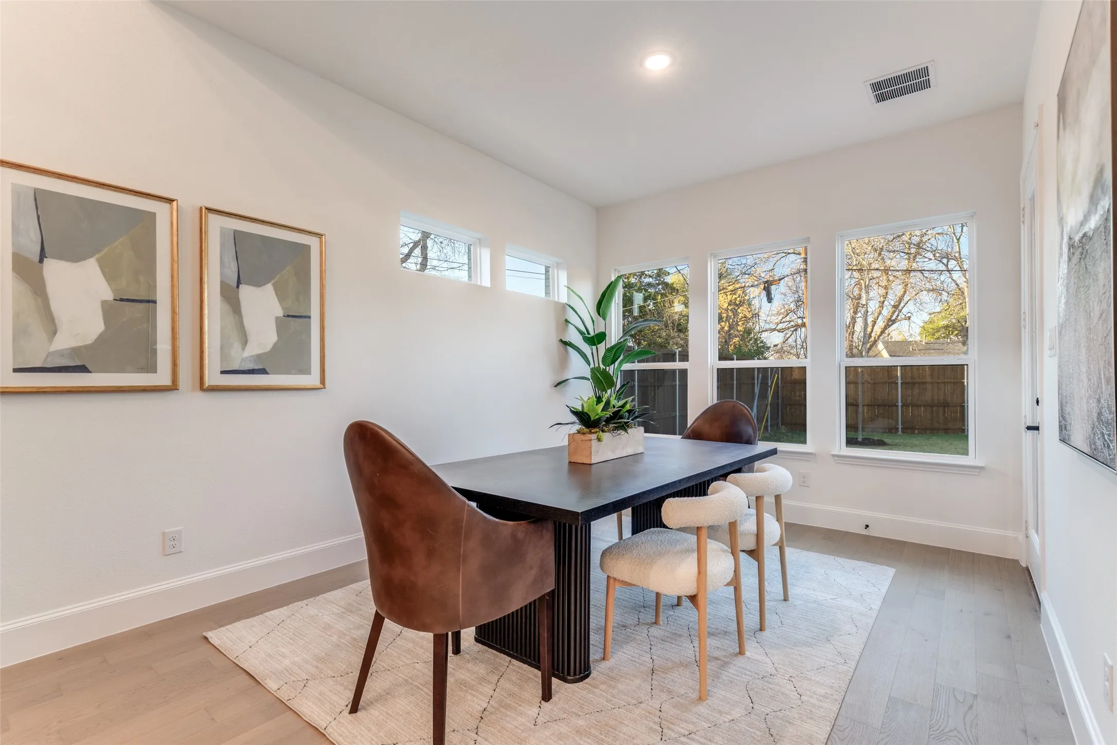 Dining room with light wood-type flooring and recessed lighting