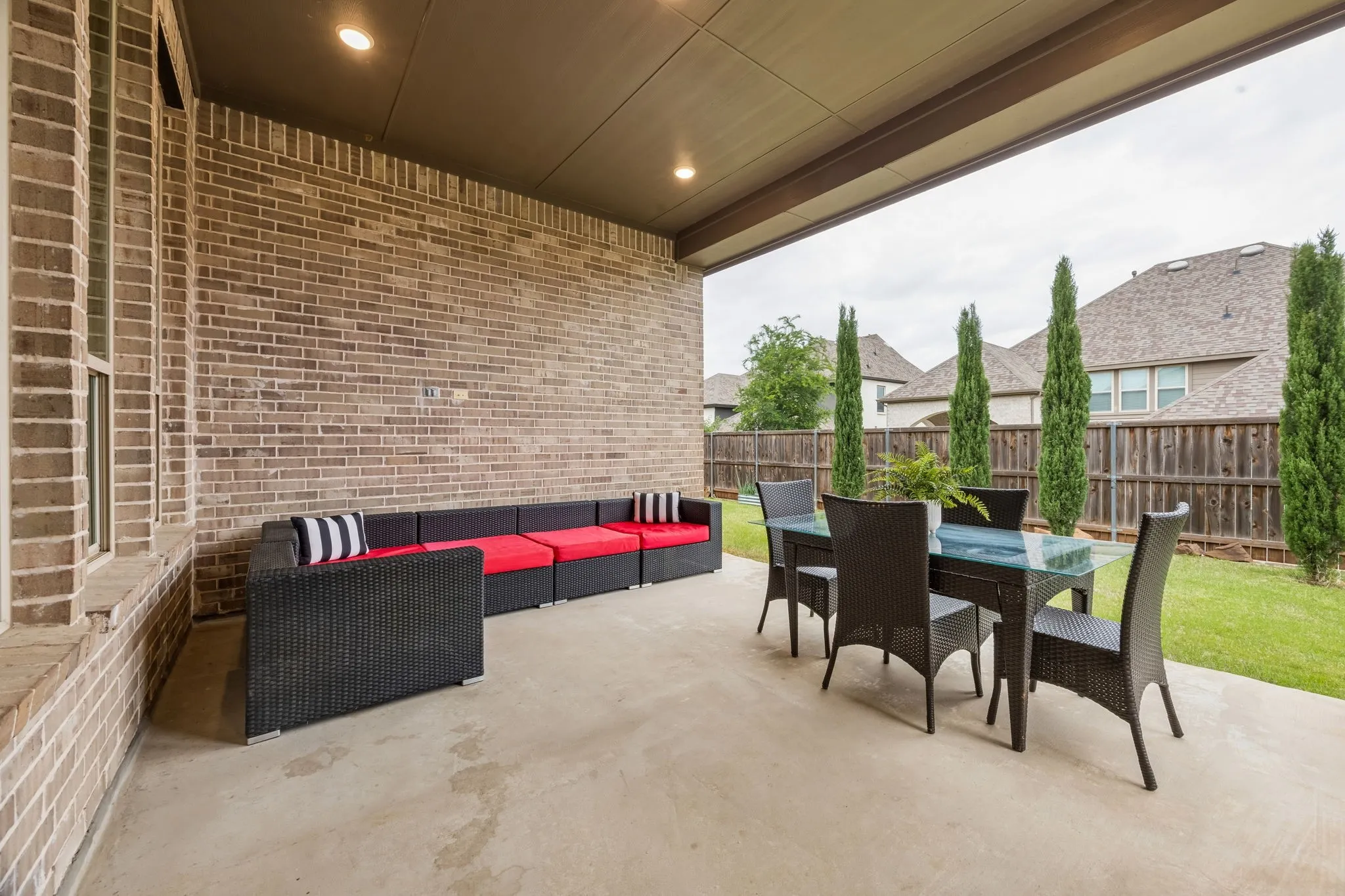 Covered patio featuring a concrete surface, recessed lighting, and a brick exterior wall