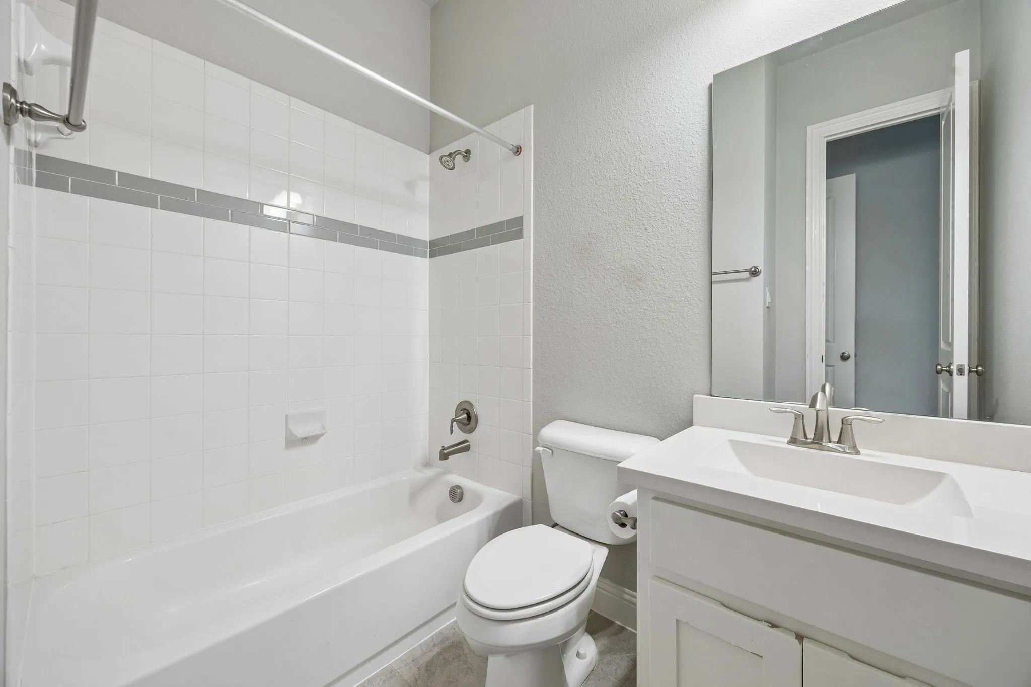 White tile tub surround with gray accent band
