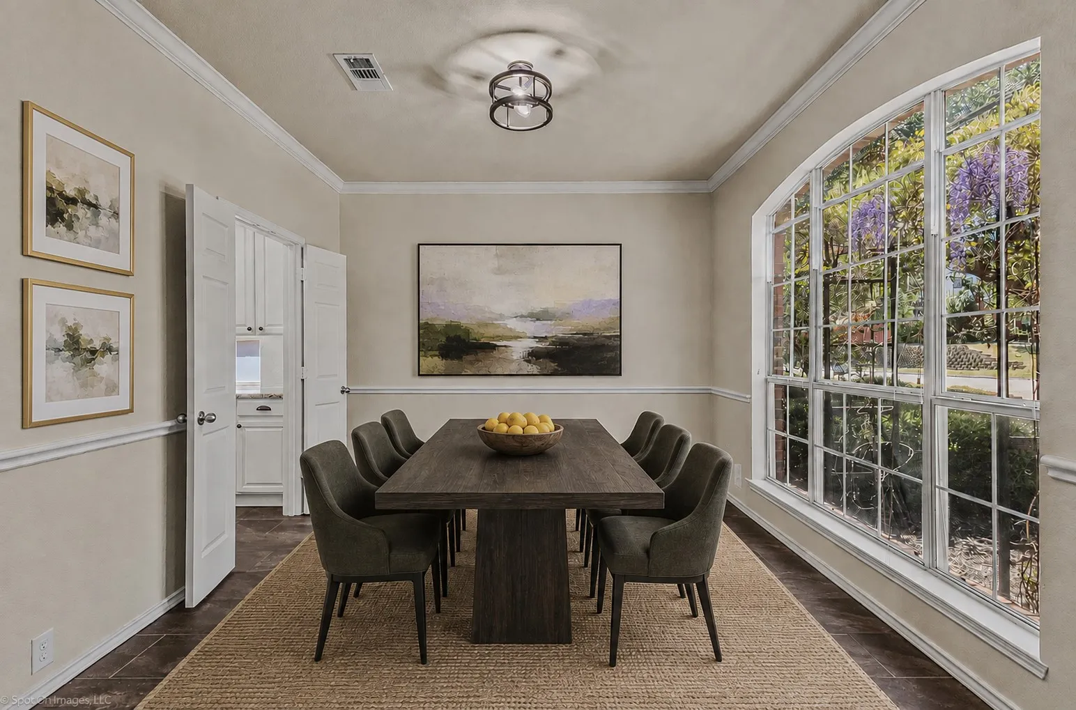 Expansive arched window, crown molding, chair rail molding, built-in cabinetry, and a contemporary ceiling light fixture