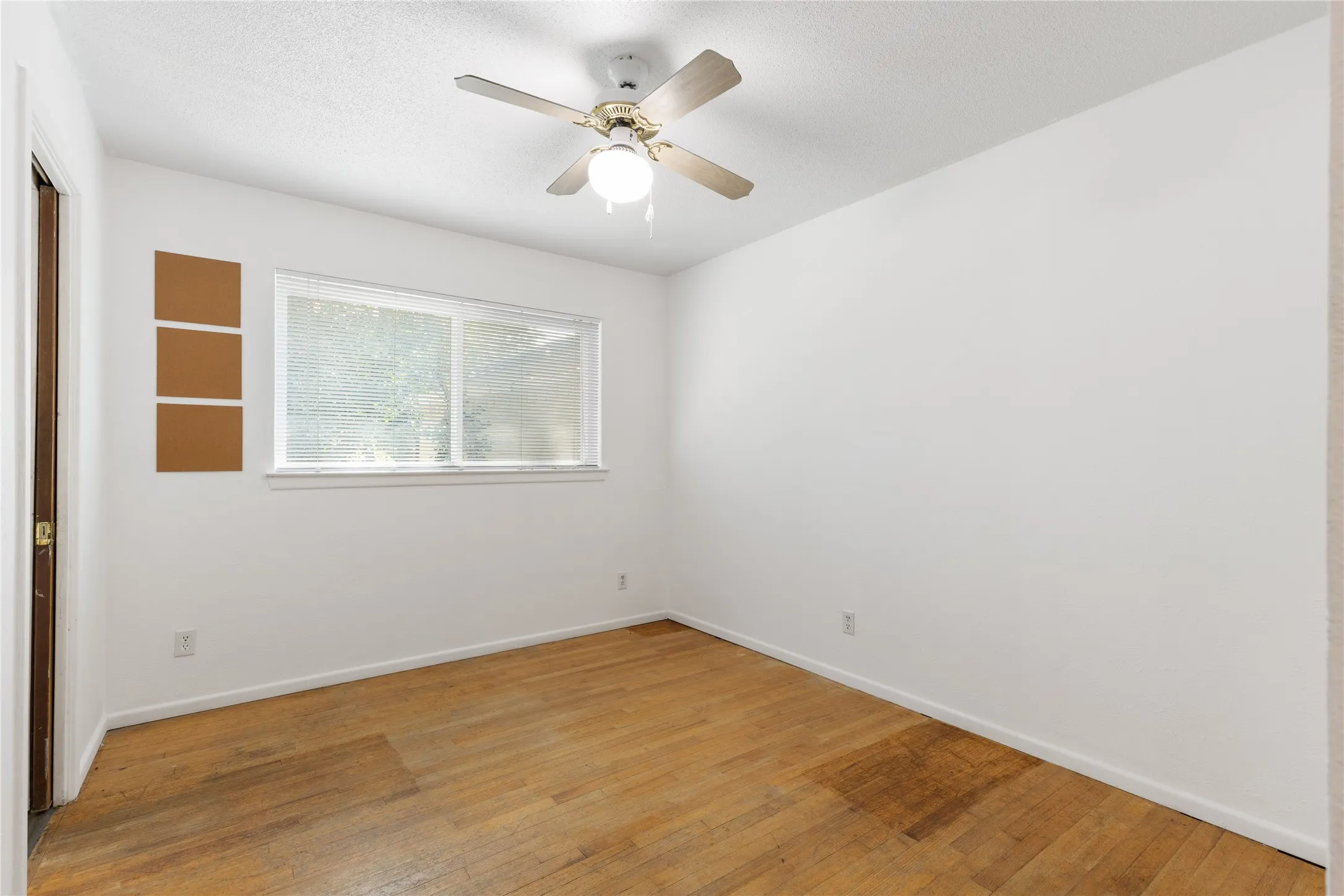 Recessed window, wood-finish flooring, ceiling fan with integrated lighting, white walls, and a white ceiling