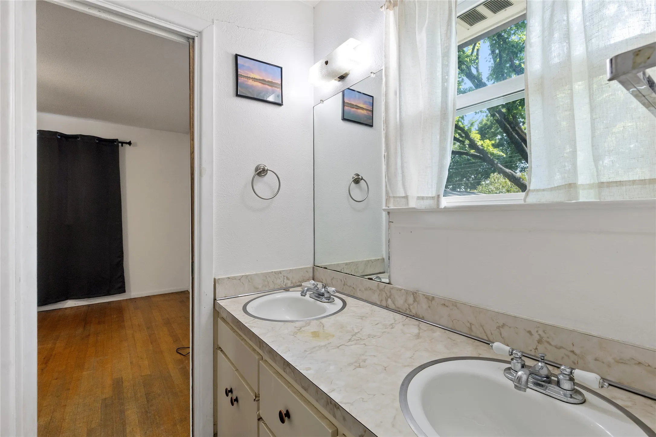 Dual undermount sinks with chrome-finish faucets, set into a stone-finish countertop with an integrated backsplash