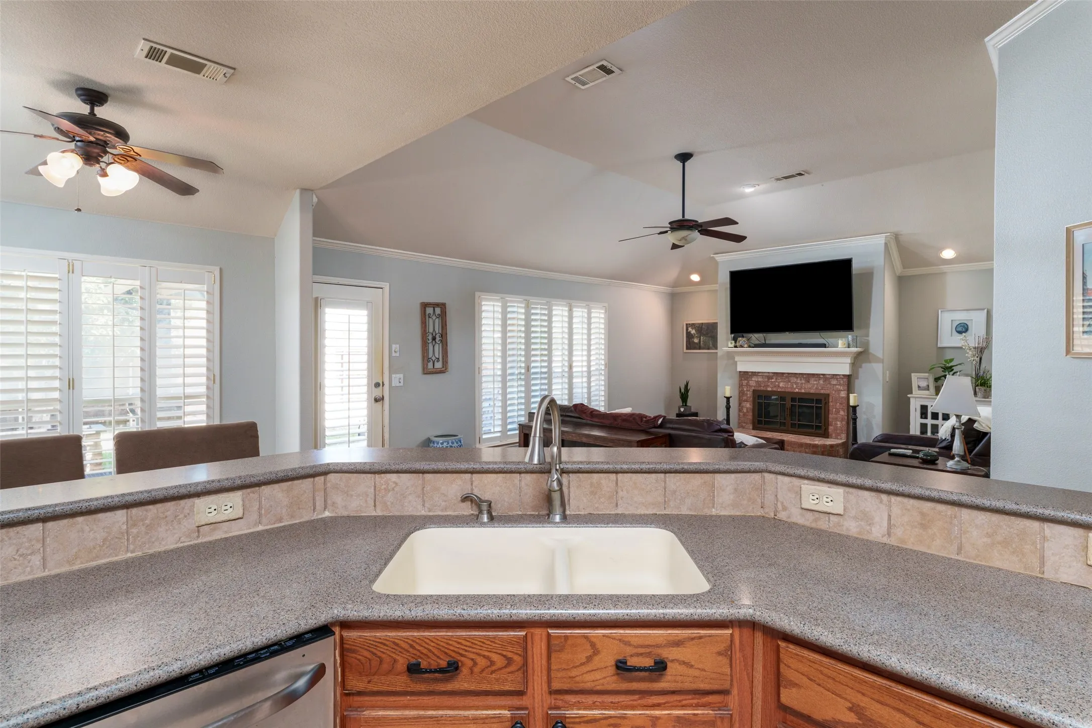 Kitchen featuring a double basin sink, durable countertop, and wood cabinetry