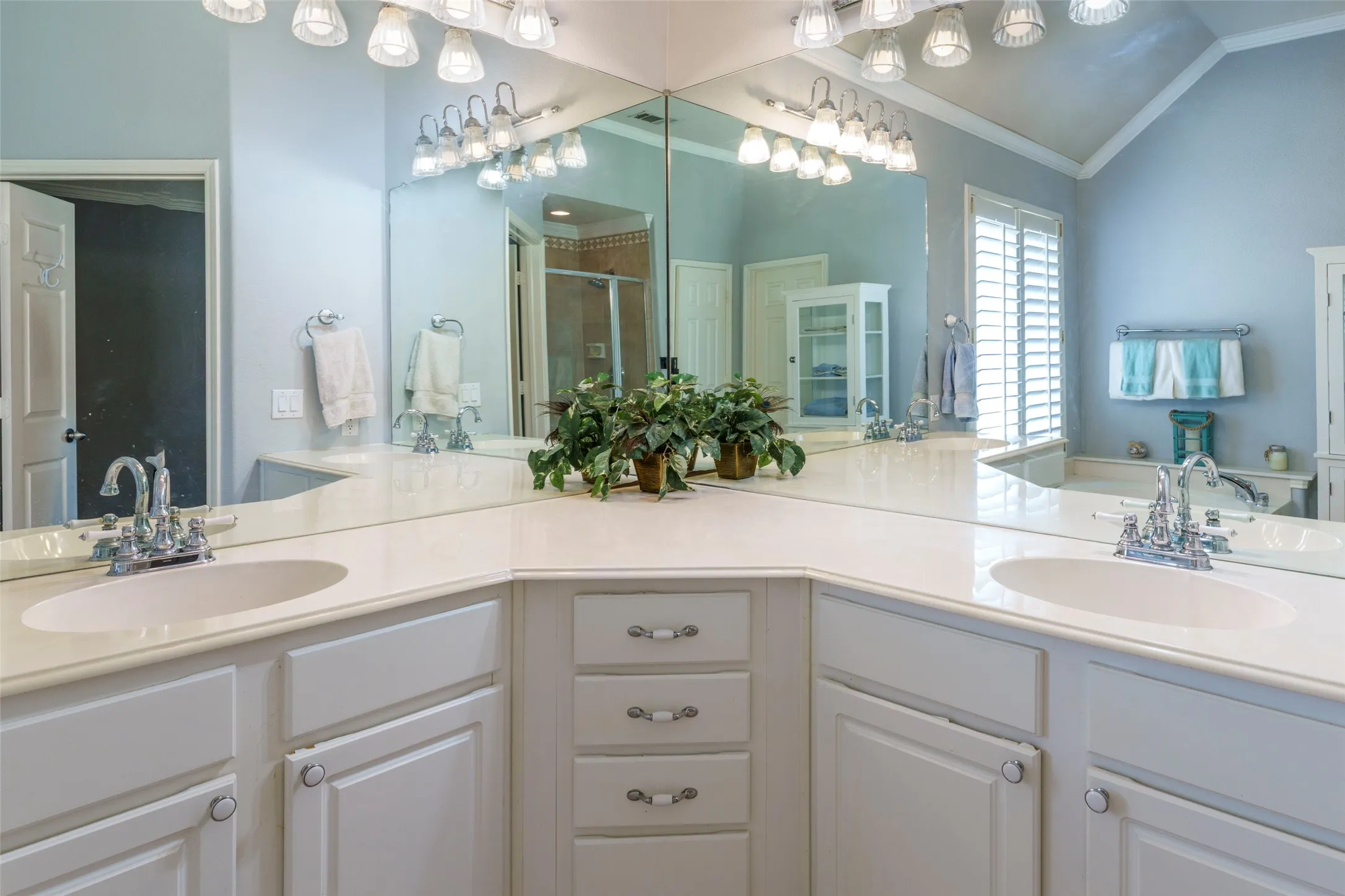 Dual vanity with white cabinetry, light-colored countertops, and chrome fixtures