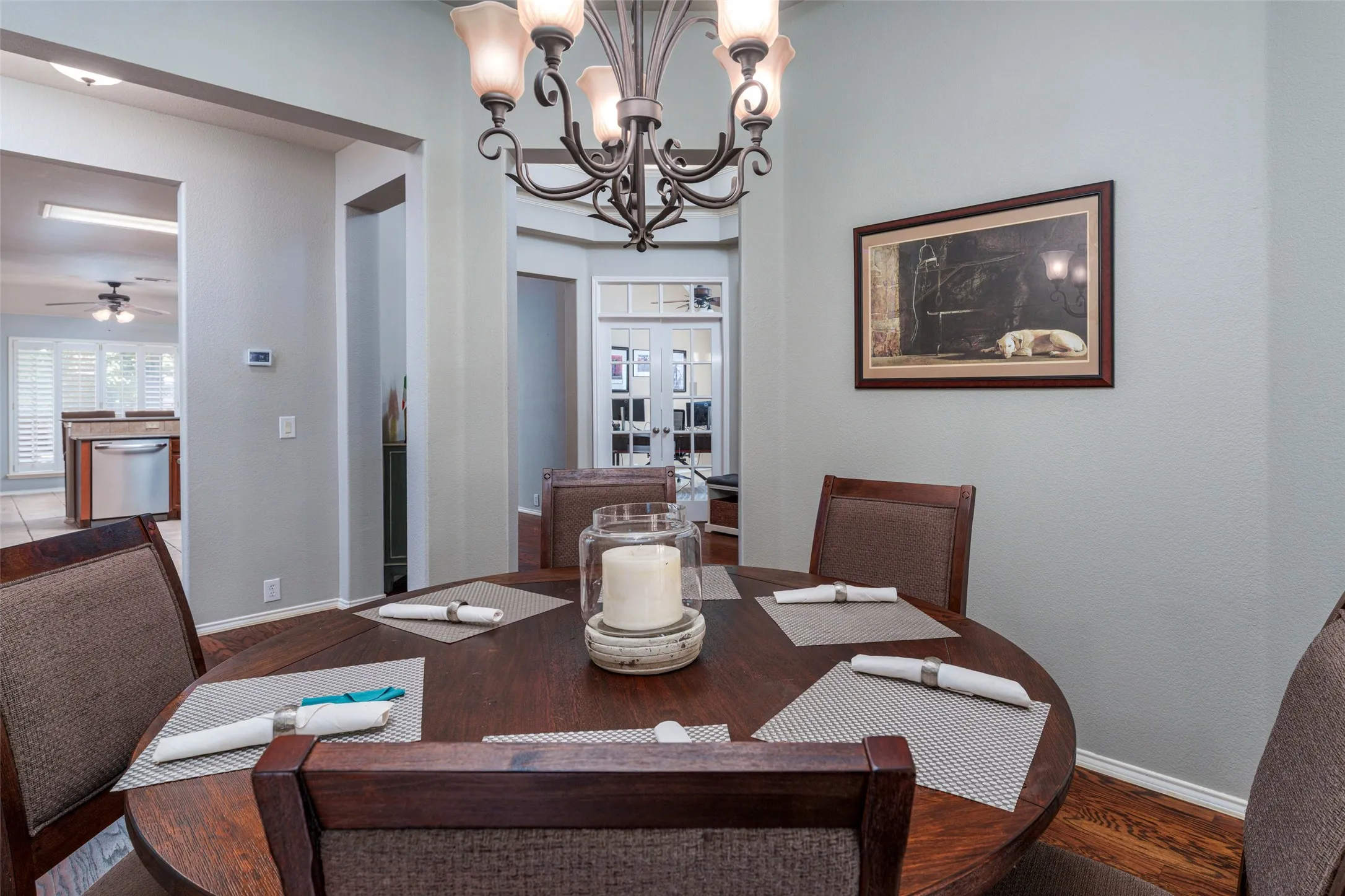 Dedicated dining area featuring a dark wood-finish round table and a wrought iron chandelier with frosted glass shades