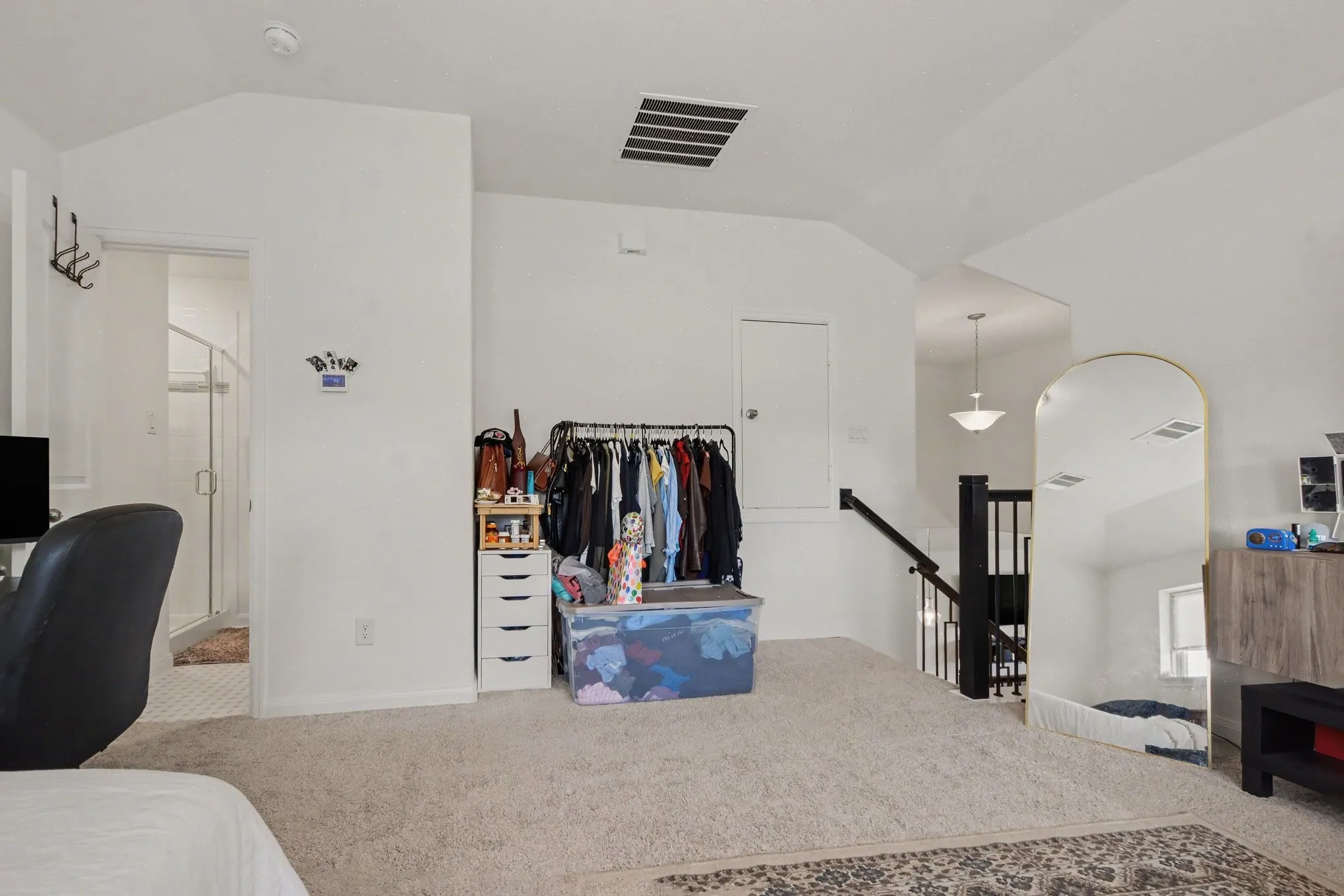 Carpeted flooring extending to the staircase with black newel posts and handrail