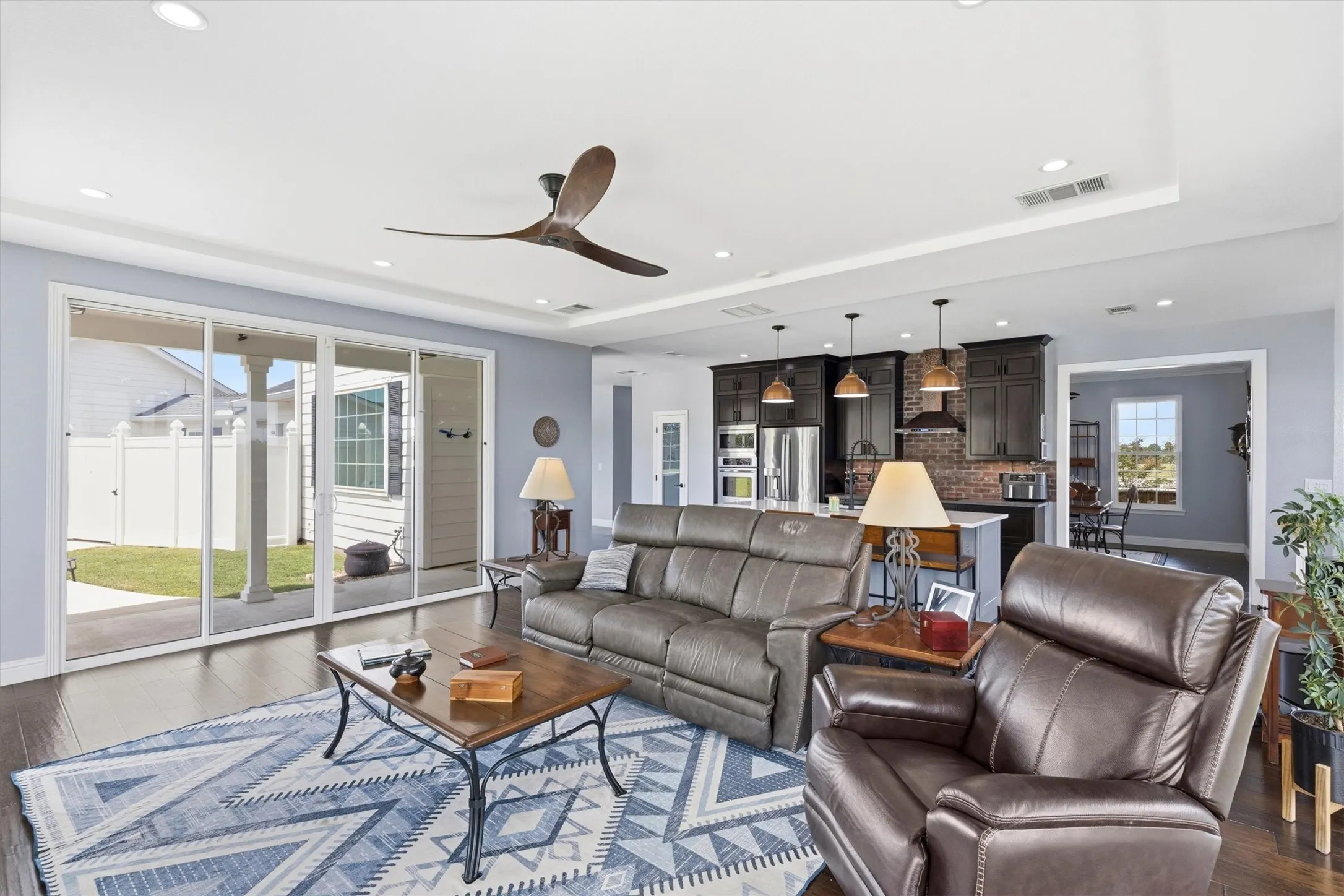 Spacious living area with wood-finish flooring, recessed lighting, and a modern ceiling fan