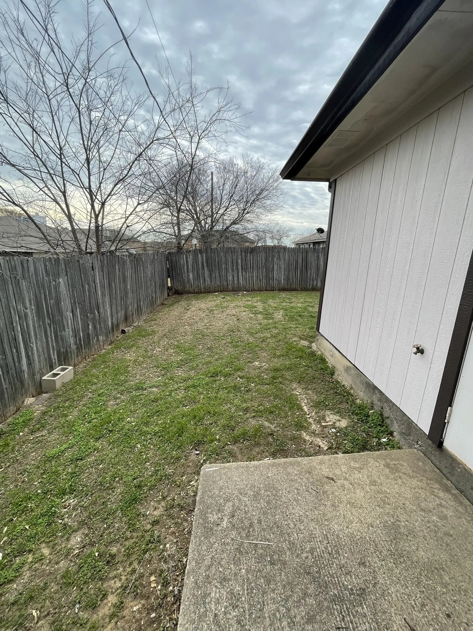 Fenced backyard featuring a concrete patio and siding exterior