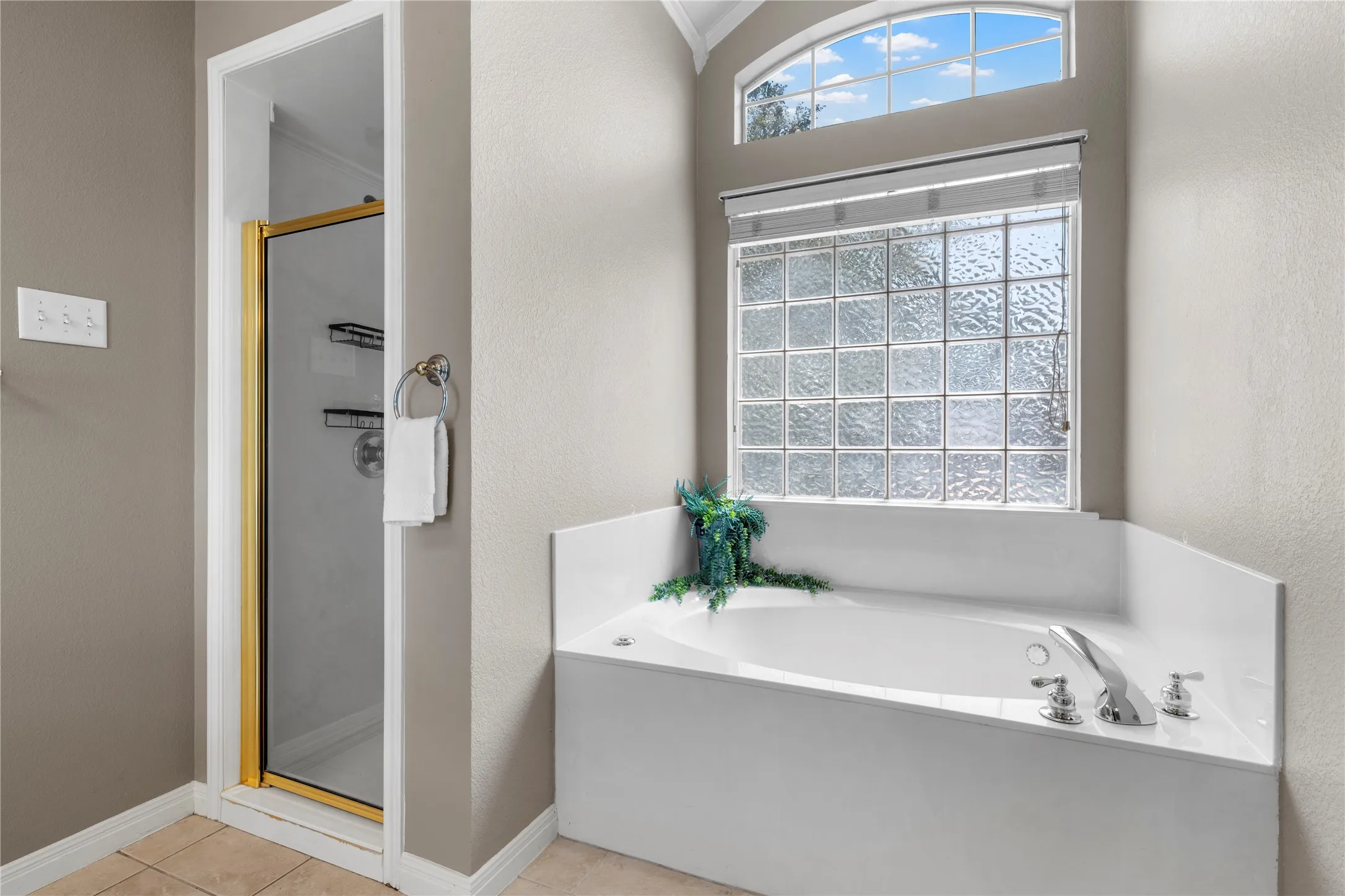 Soaking tub with deck-mounted faucet and privacy glass block window