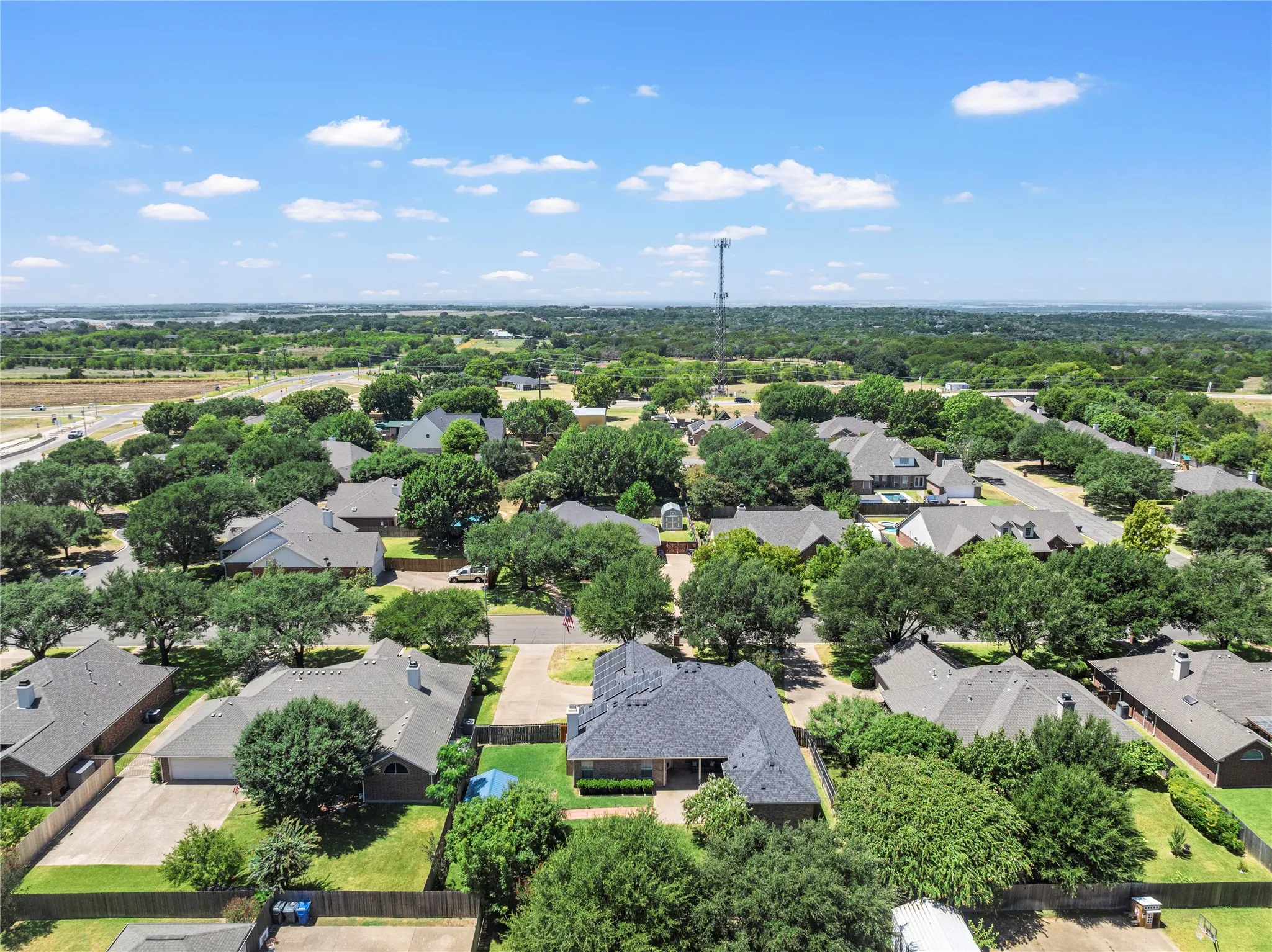 Residential neighborhood with mature trees, established homes, and paved roads