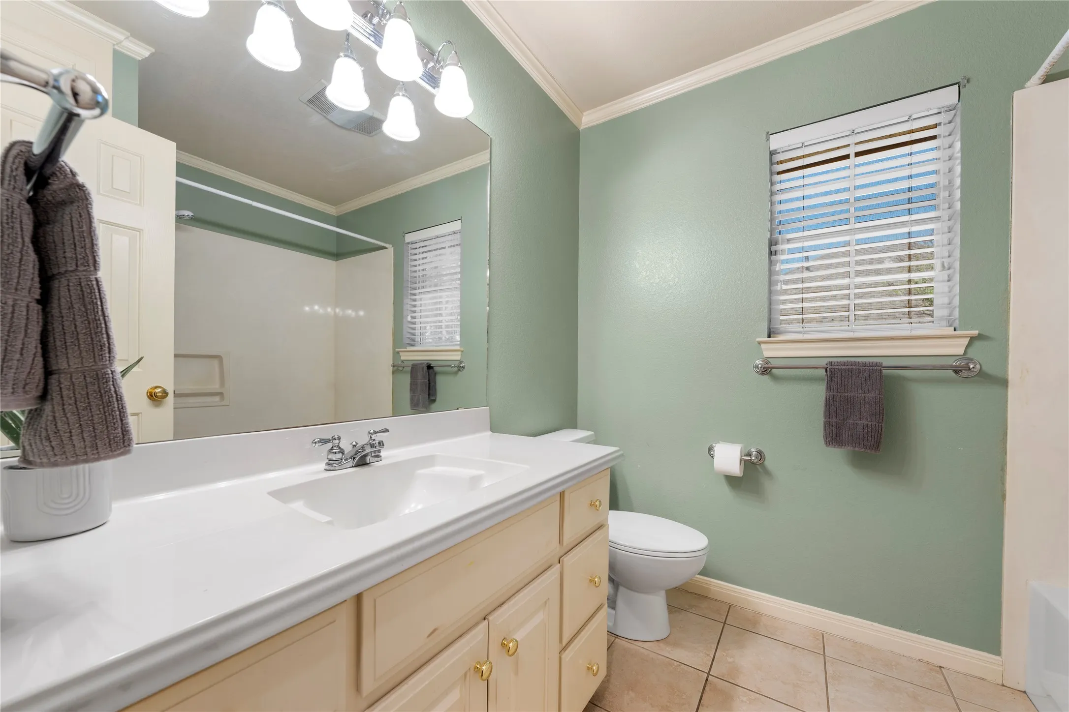 White vanity with an integrated sink, polished chrome faucet, and gold-tone hardware