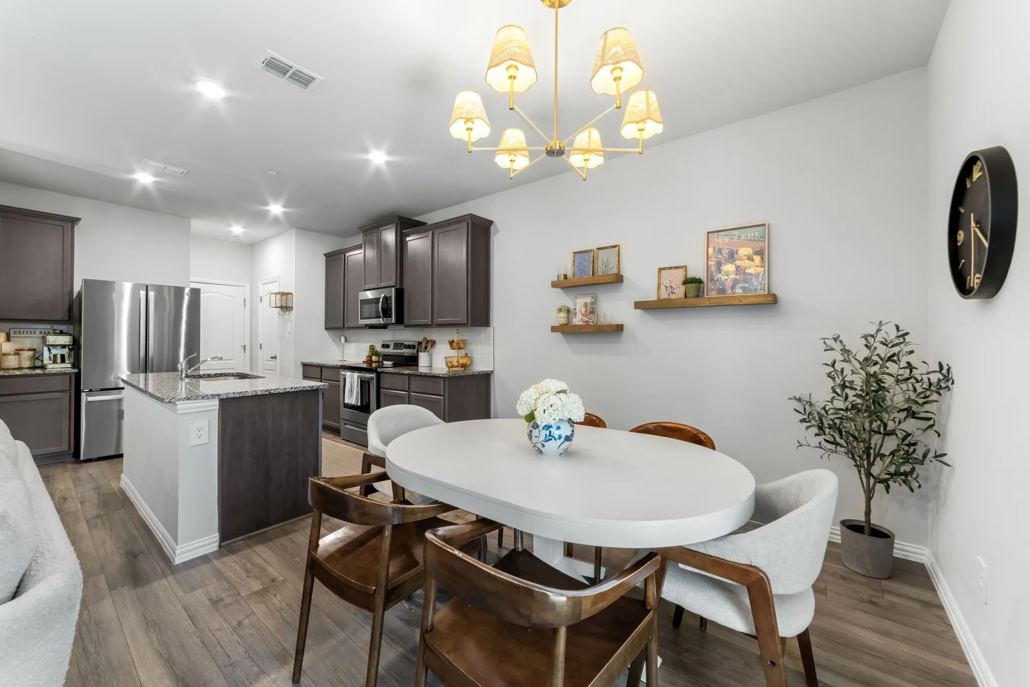 Open-concept living space featuring wood-finish flooring, recessed lighting, and a modern chandelier