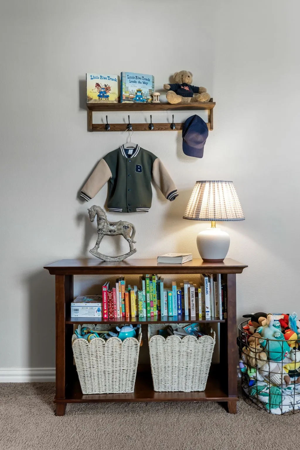 Charming bedroom corner featuring warm wood-finish cabinetry with woven storage baskets, built-in wall shelving with hooks for organization, and soft ambient lighting from an attached table lamp