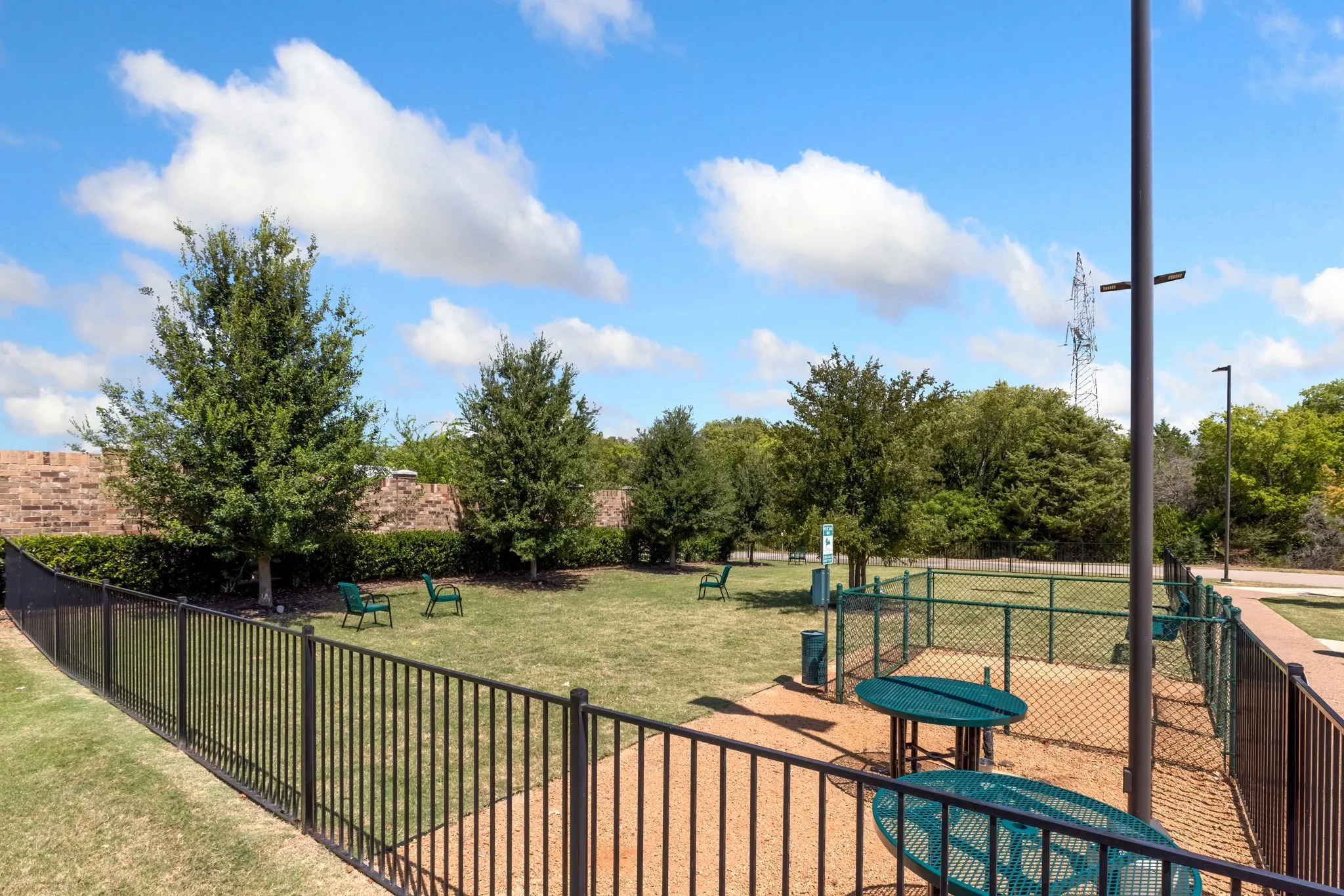 Expansive recreational grounds featuring a manicured lawn, mature shade trees, and dedicated play area with equipment