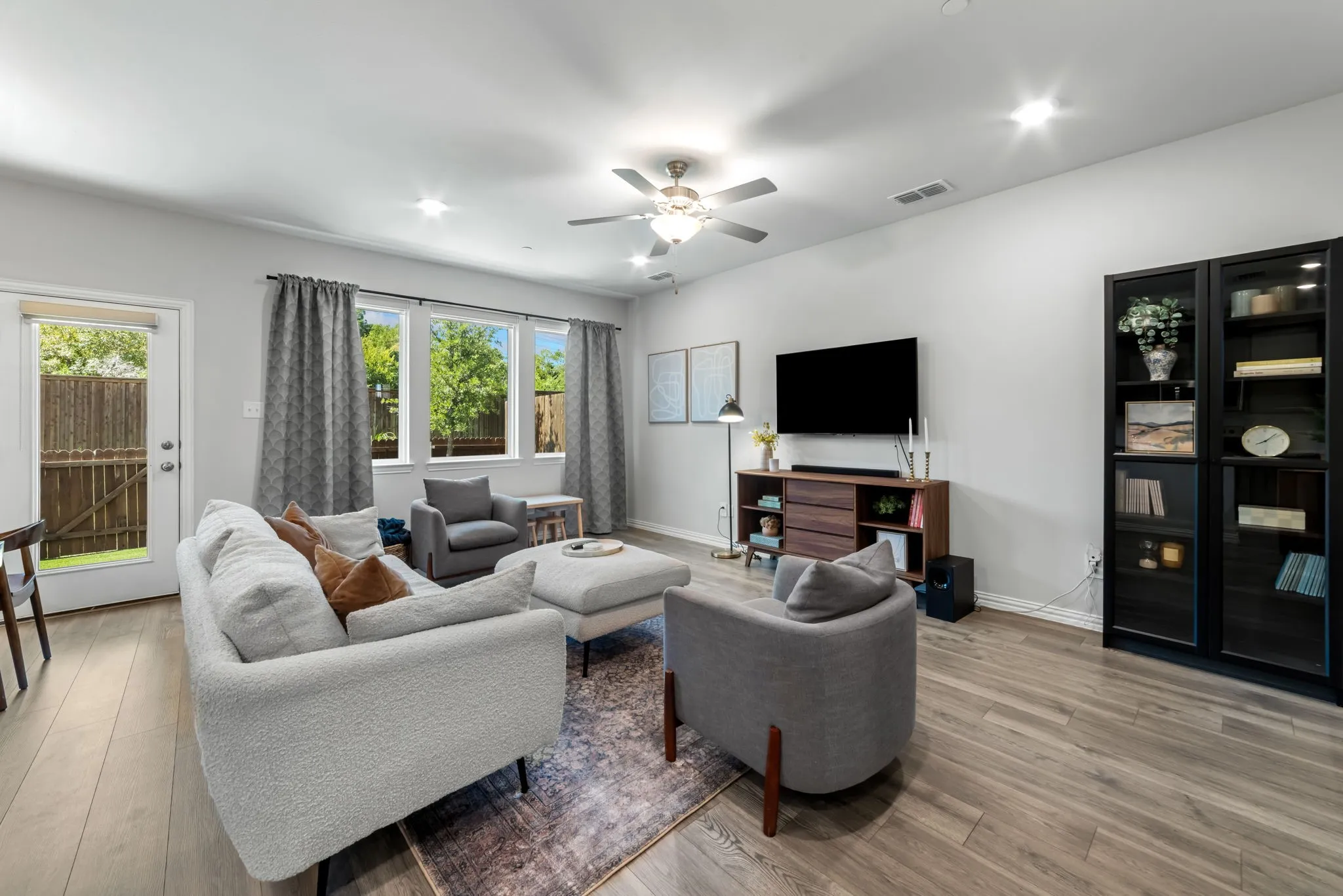 Spacious living area featuring wood-finish flooring, recessed lighting, and a ceiling fan