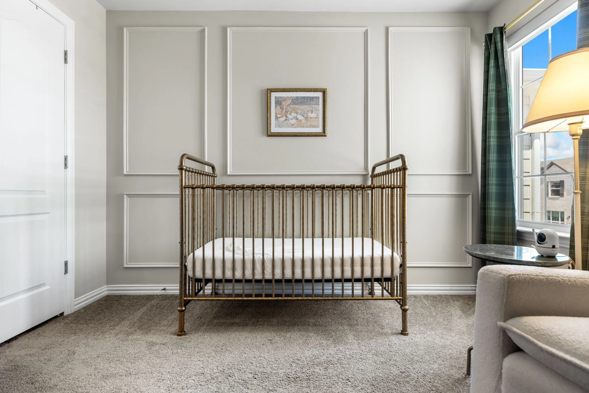 Nursery featuring architectural wall paneling with coordinating trim molding, carpet flooring, large casement windows with green drapery, and recessed lighting