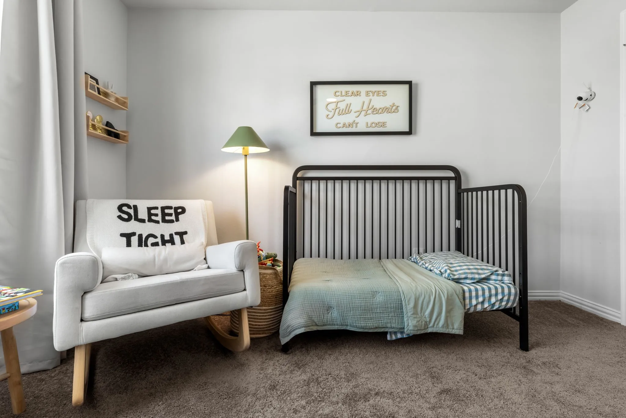 Cozy bedroom featuring a black metal bed frame, soft-finish carpet flooring, and neutral wall finishes