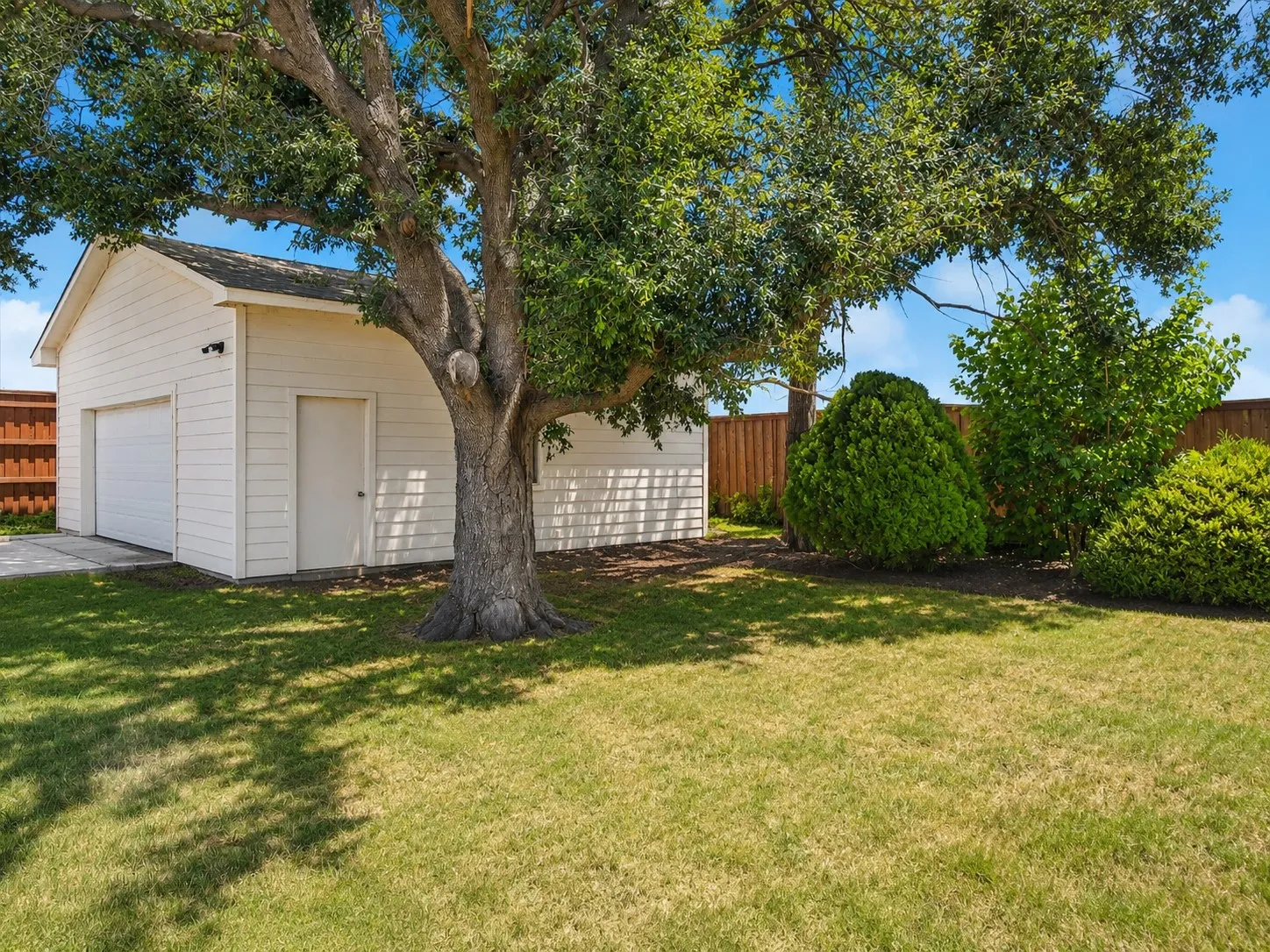 Detached garage with two garage doors and a separate entry door