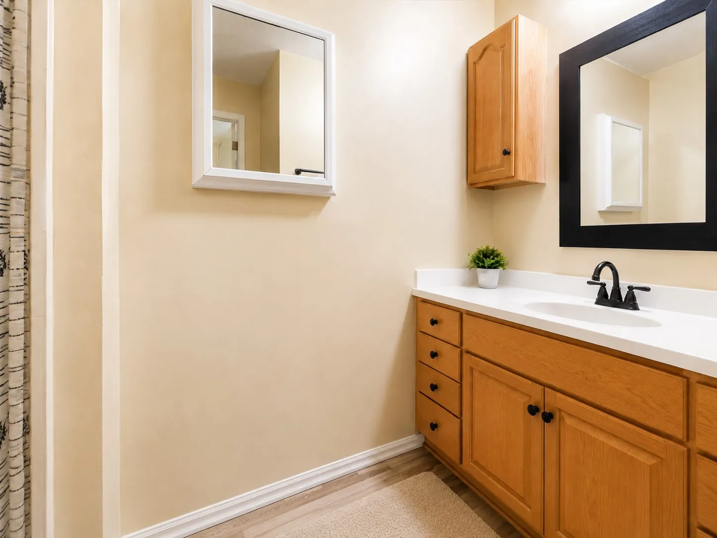 Vanity with wood-finish cabinetry, white countertop, and integrated sink