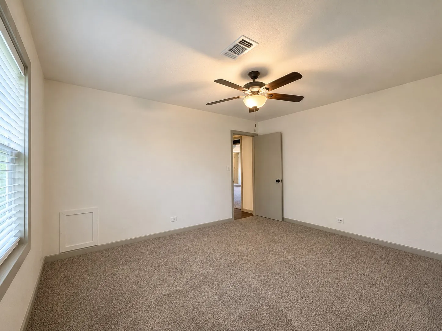 Carpeted flooring, ceiling fan, window with blinds, and neutral wall tones