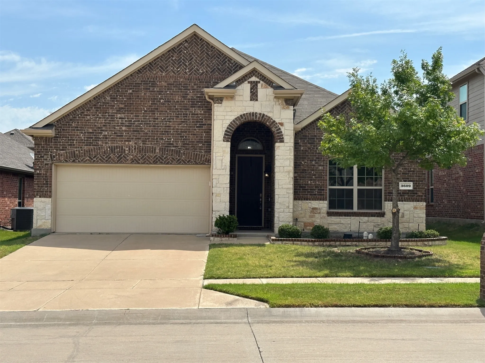 Brick and stone facade featuring an arched entryway