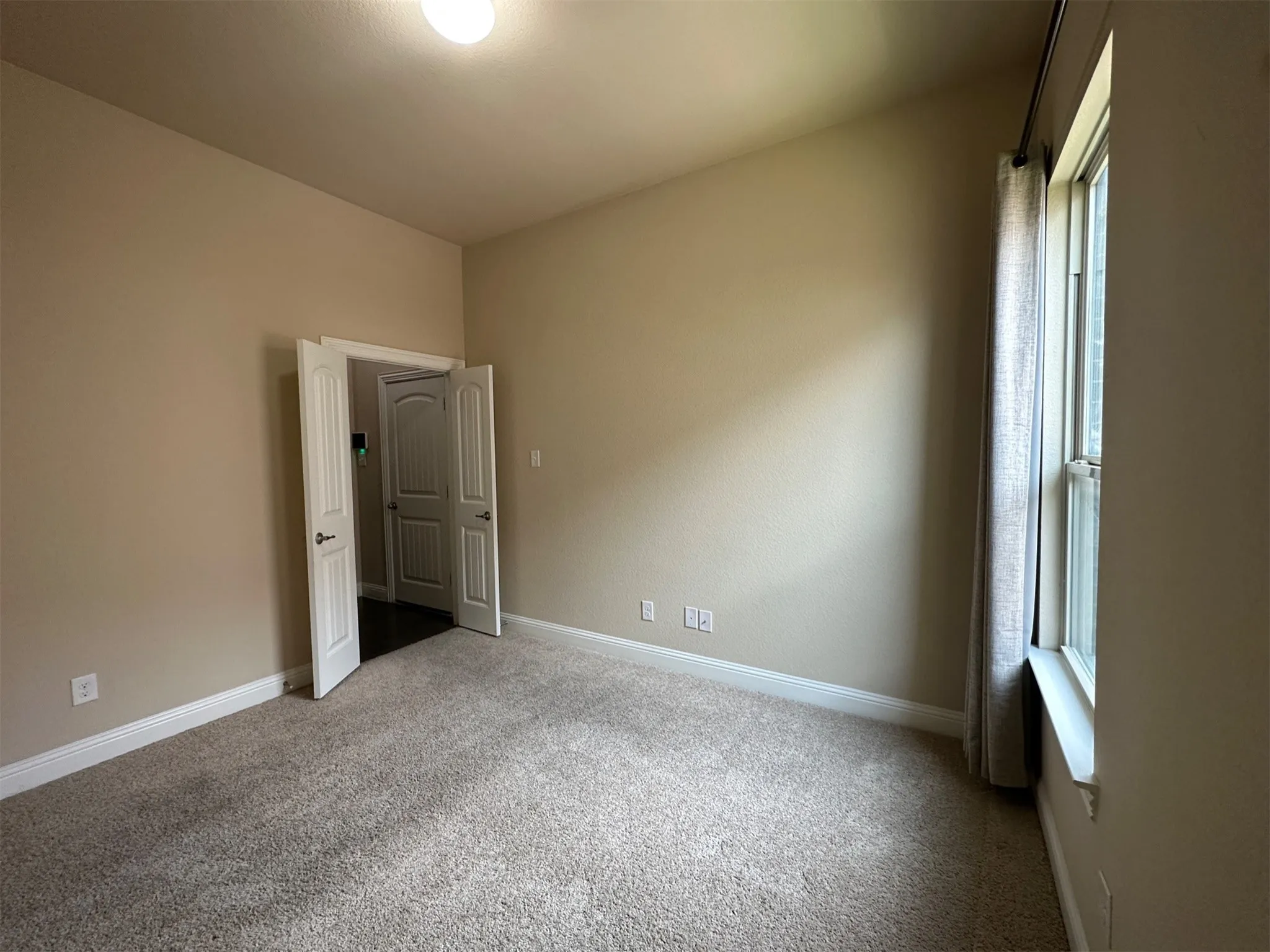 Room featuring neutral carpet flooring and light beige wall paint