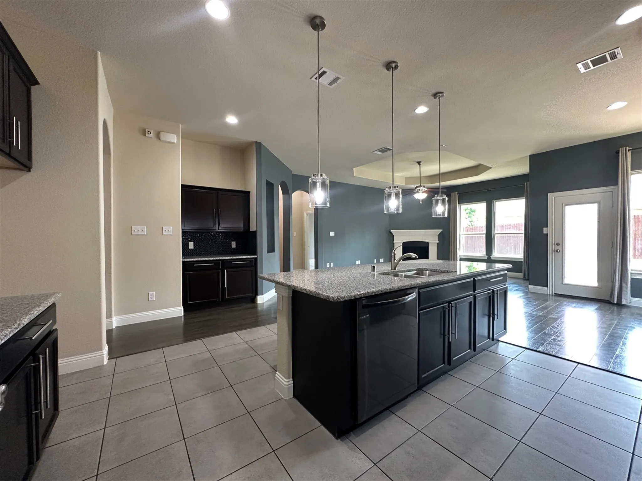 Kitchen island with granite countertops, stainless steel sink, and pendant​​‌​​​​‌​​‌‌​‌‌​​​‌‌​‌​‌​‌​​​‌​​ lighting