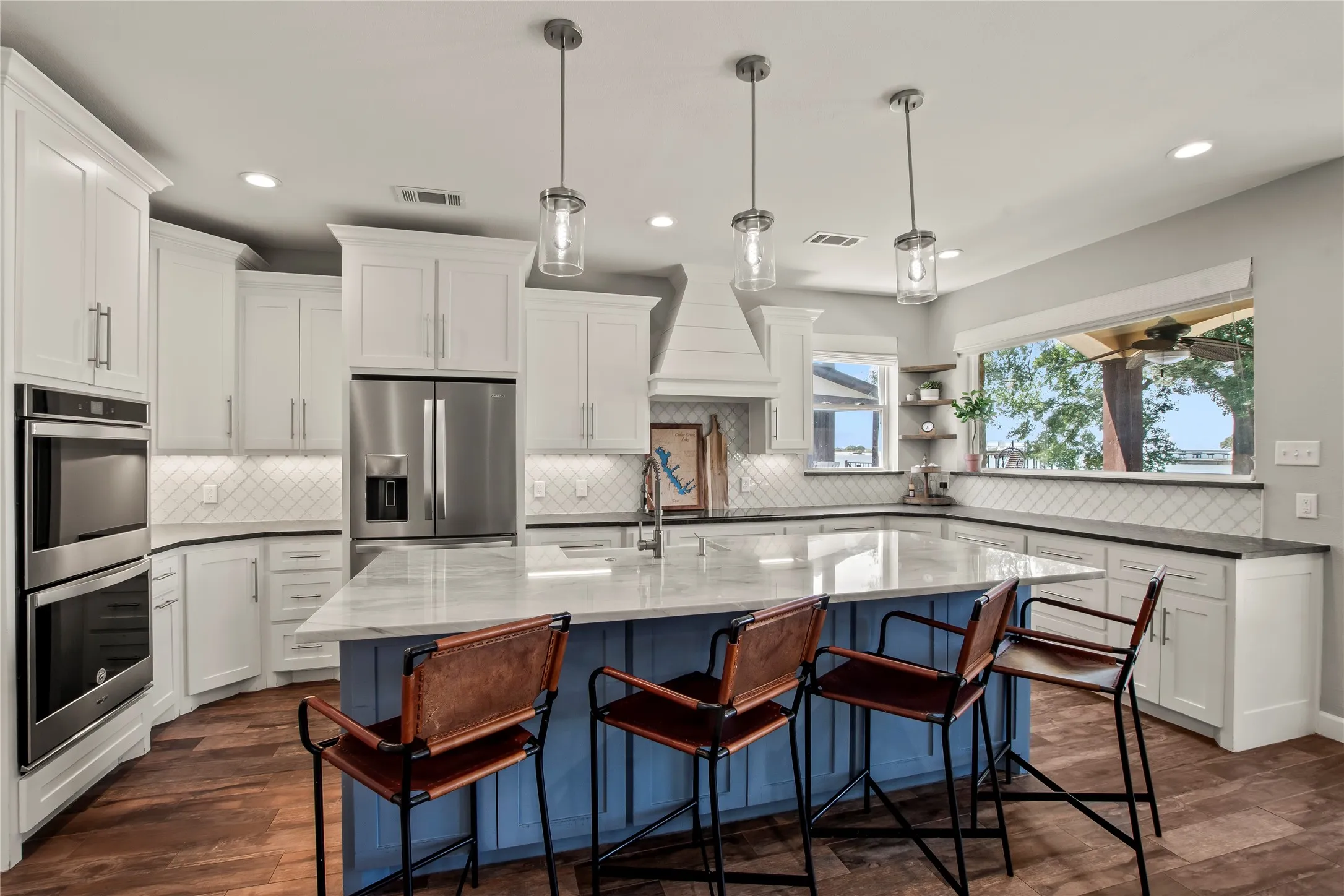 Kitchen with double ovens, cooktop, island seating, quartz and leather granite counter tops, shaker style cabinets