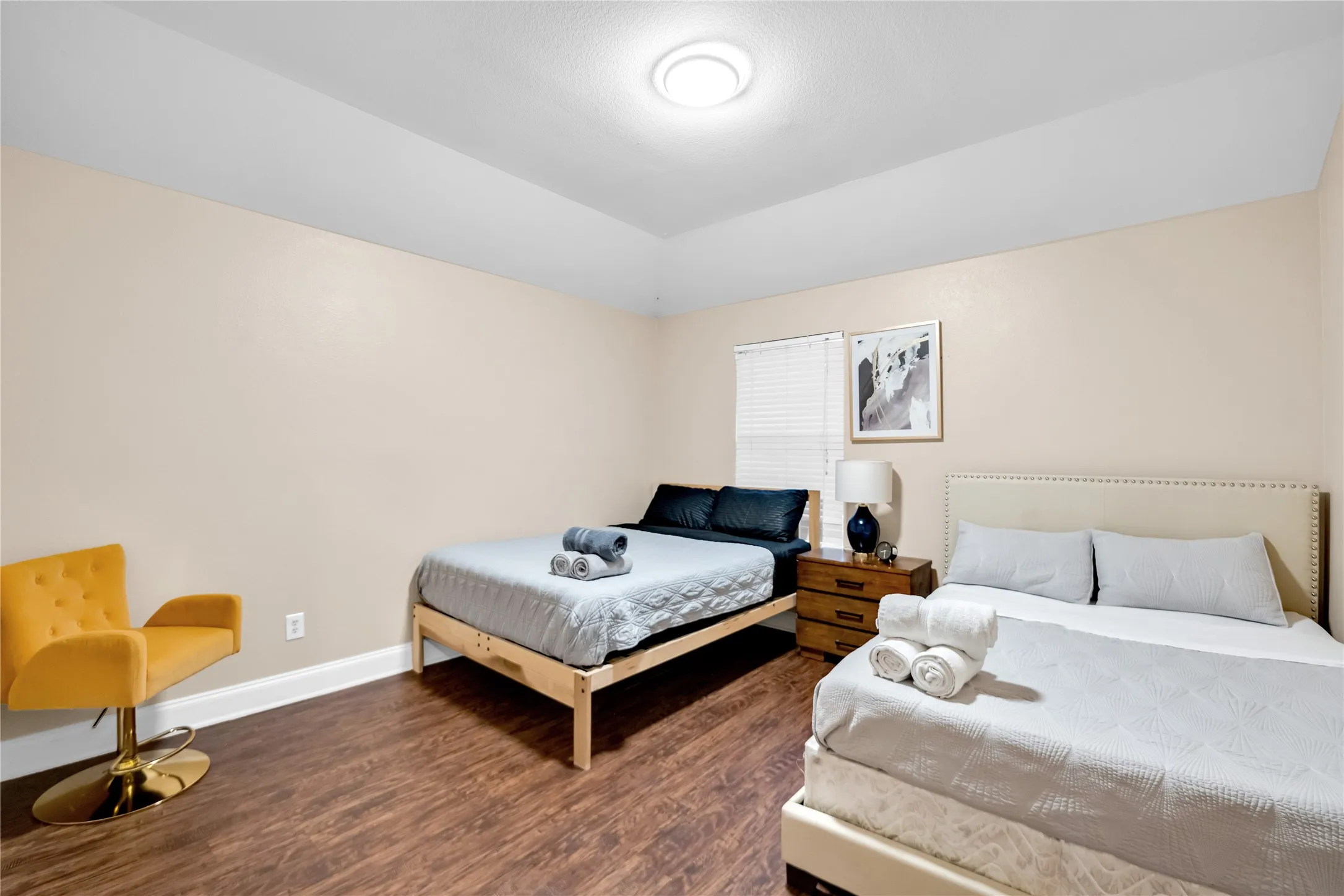 Wood-finish flooring, recessed ceiling lighting, light-toned wall paint, and window with horizontal blinds