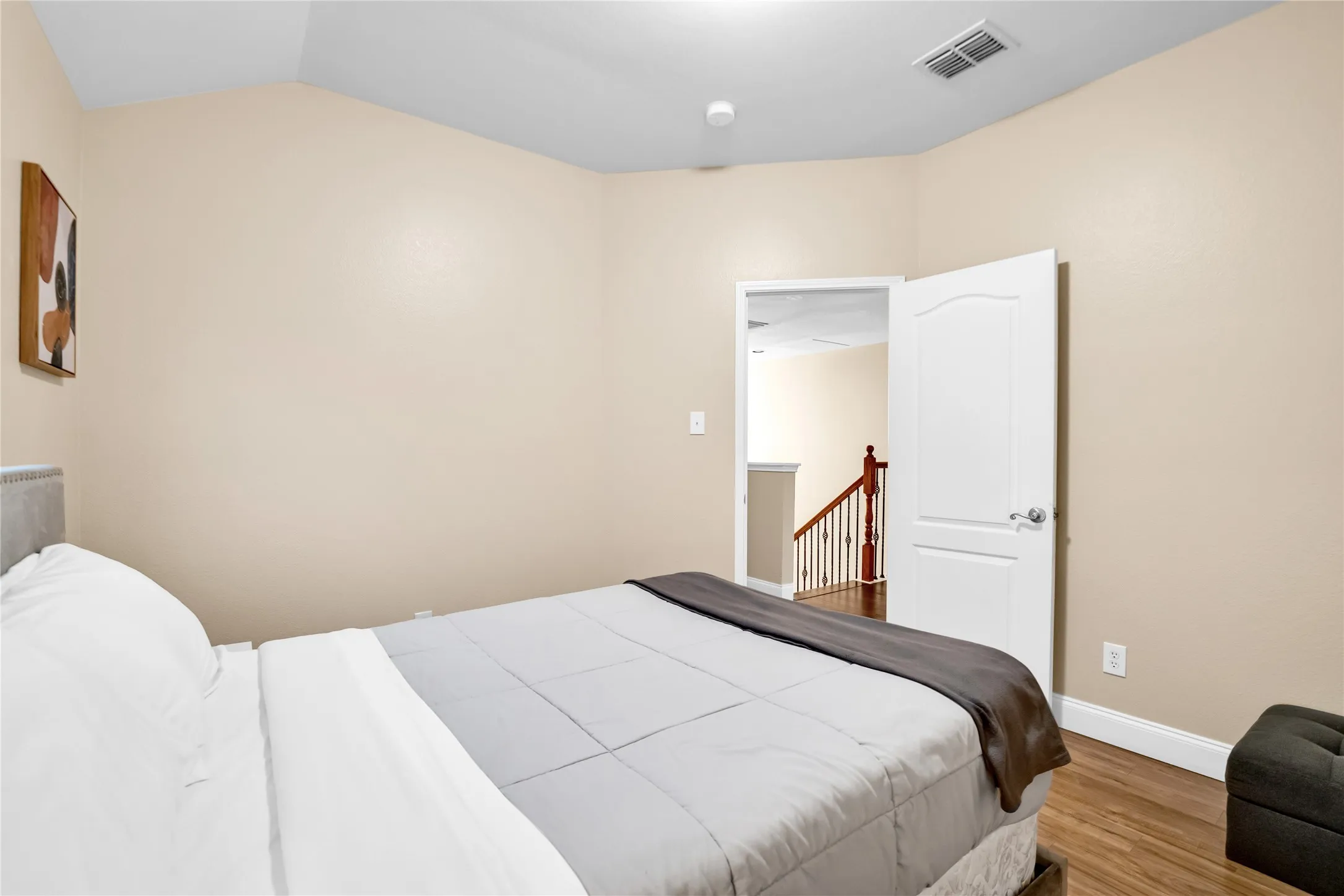 Wood-finish flooring, neutral wall tones, and a white interior door