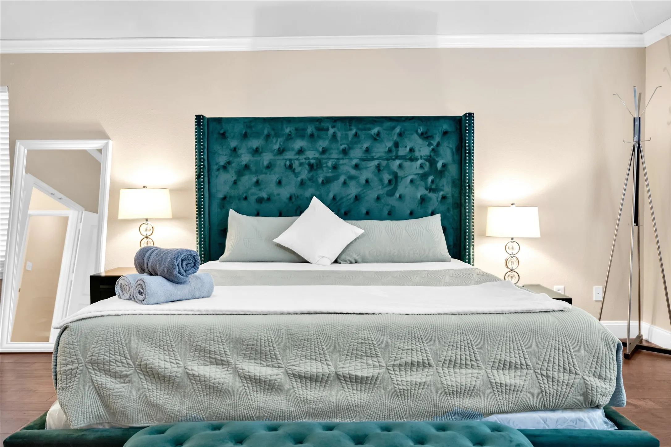 Upholstered bed frame with tufted headboard, two bedside tables, and two table lamps