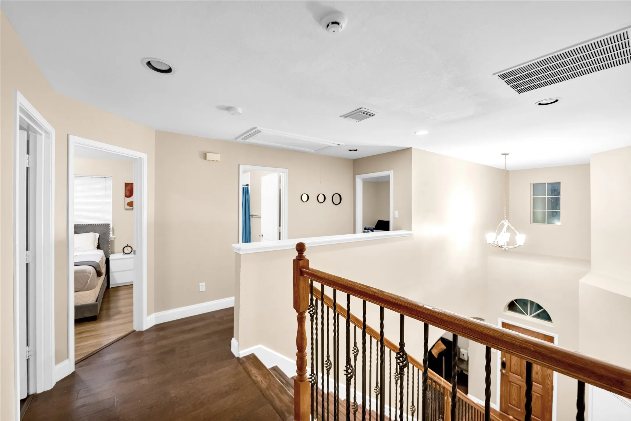 Staircase featuring dark wood handrails and decorative wrought iron balusters