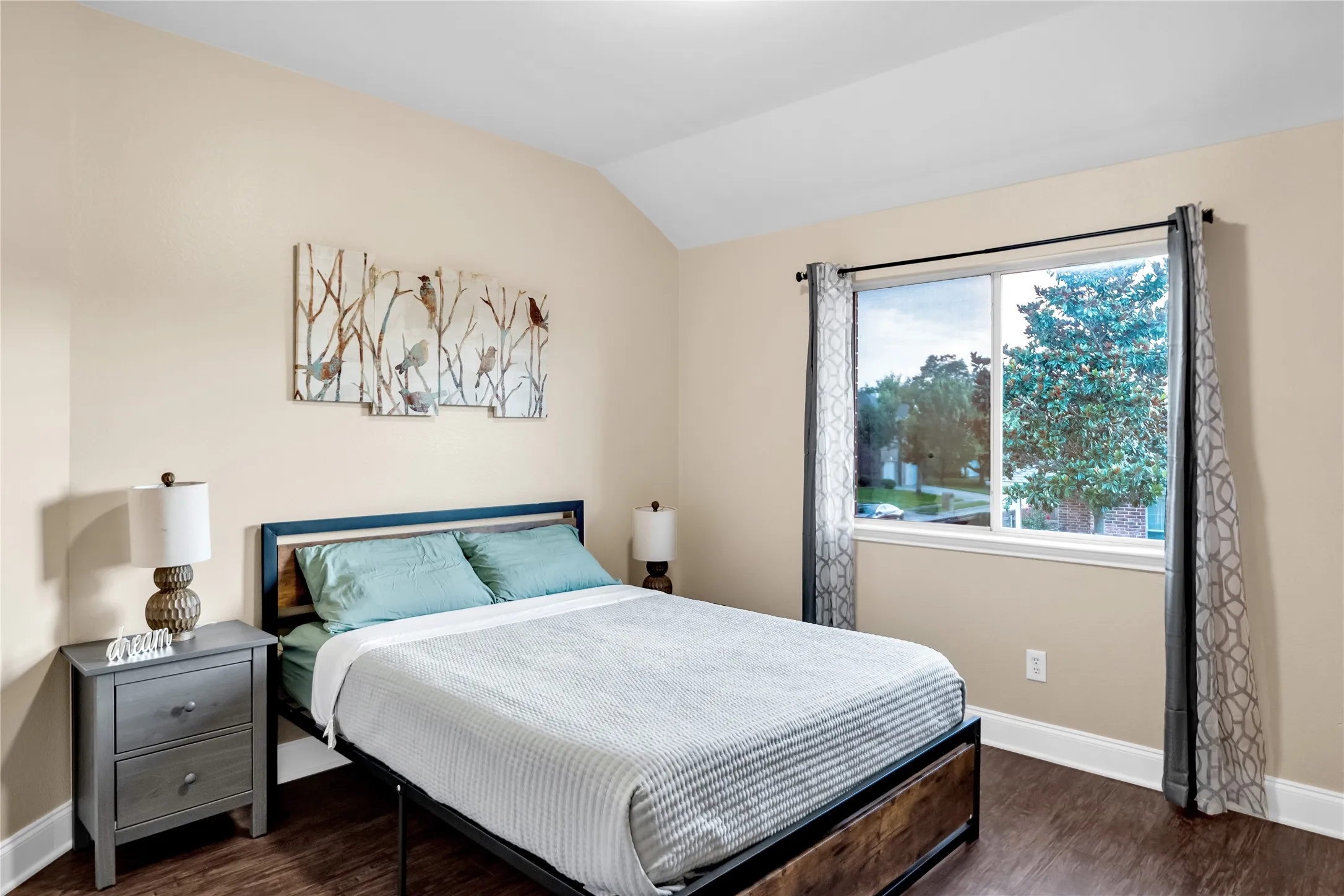Vaulted ceiling, wood-finish flooring, single window, and neutral wall tones