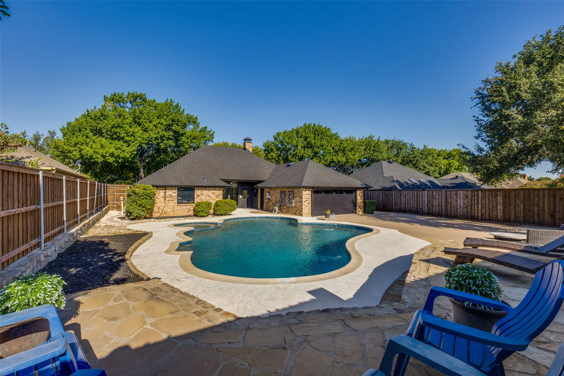 View of Pool and Back yard from an Elevated Stone Patio Area