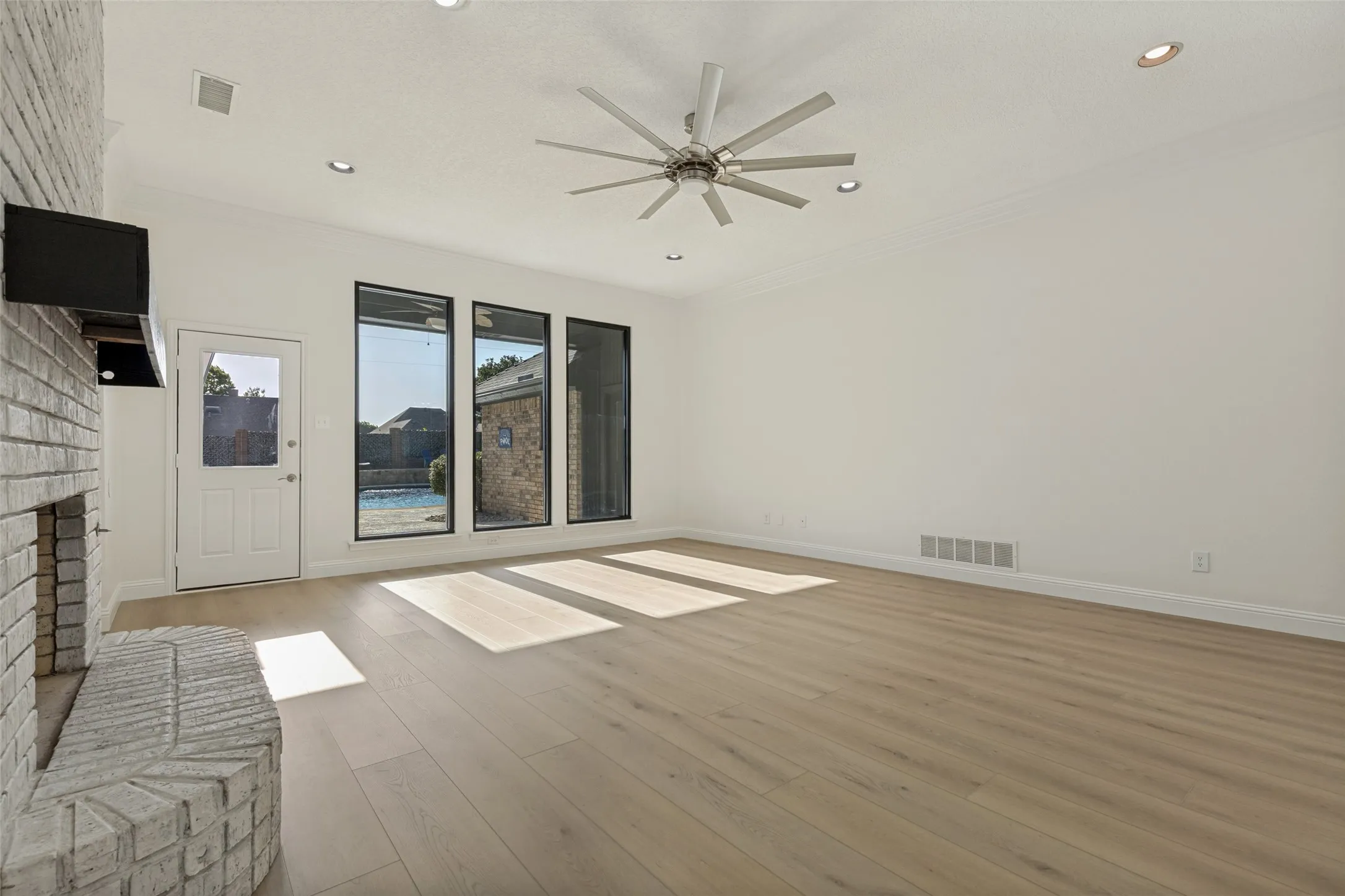 View of Living Room showcasing Large Windows looking out onto the Gorgeous Pool and Patio