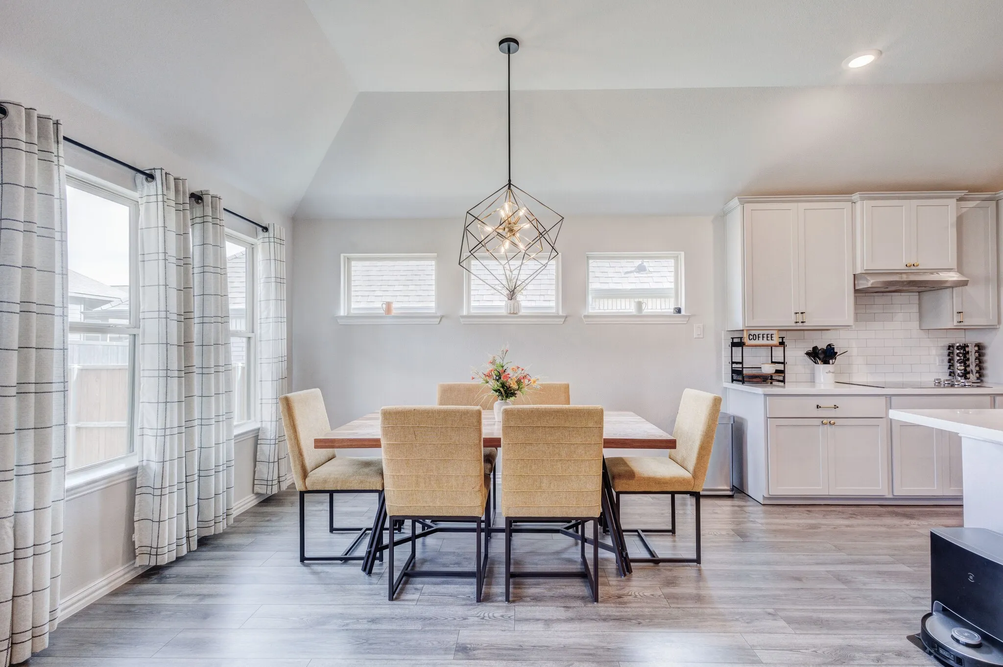 Kitchen with white cabinetry, subway tile backsplash, and stainless steel hood