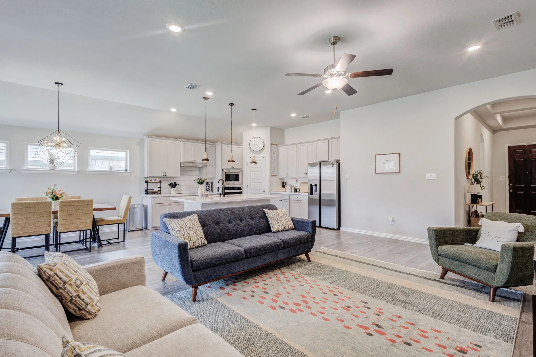 Open-concept living space featuring wood-finish flooring, recessed lighting, and a ceiling fan