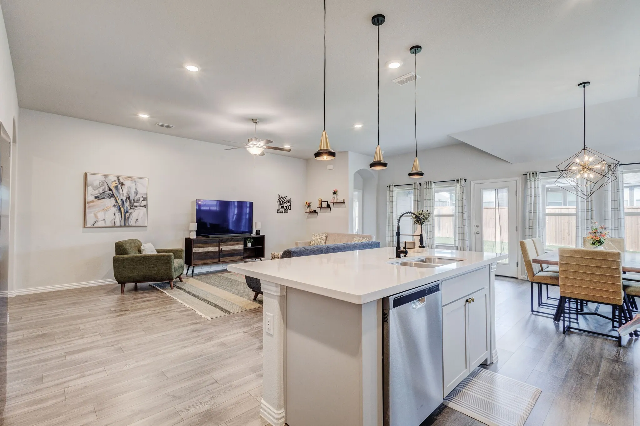 Open-concept living space featuring wood-finish flooring, recessed lighting, and a kitchen island with a quartz countertop