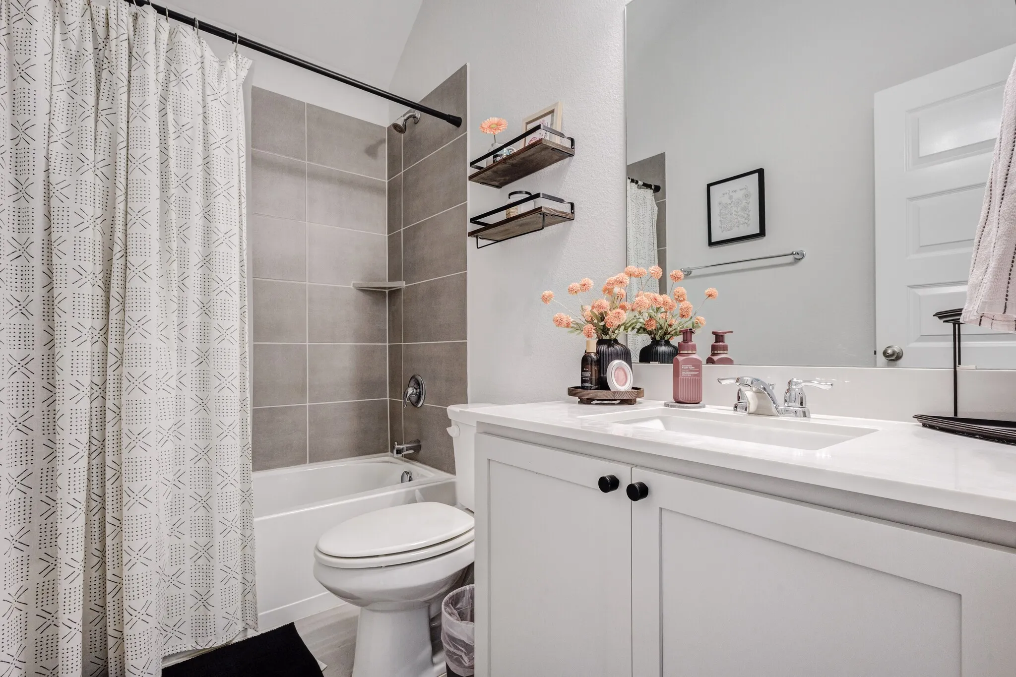 White vanity with shaker-style cabinetry, a built-in sink, and a chrome faucet