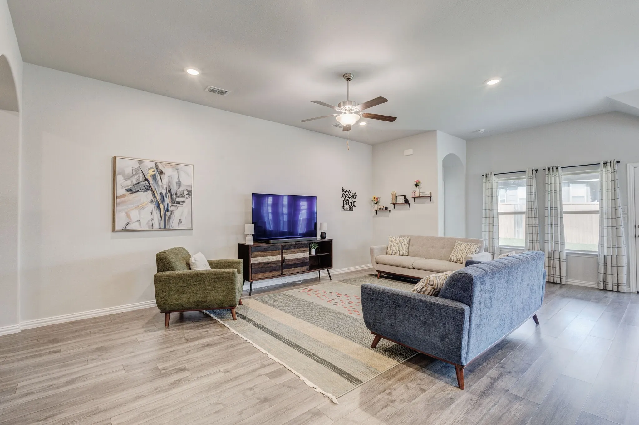 Spacious living area featuring wood-finish flooring, recessed lighting, and a ceiling fan